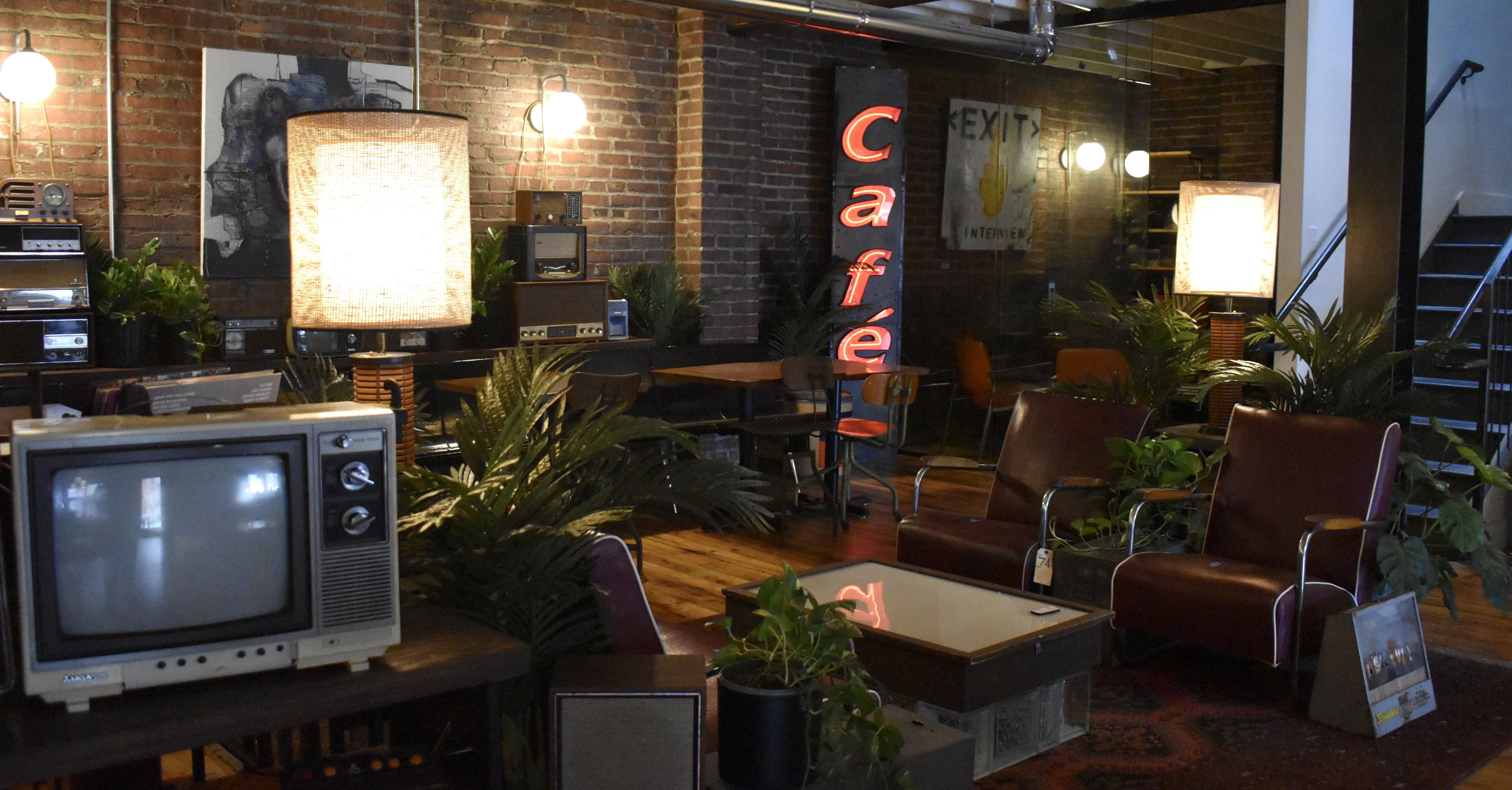 Cozy interior coffeeshop vibes with brick walls and a sign reading "cafe. "
