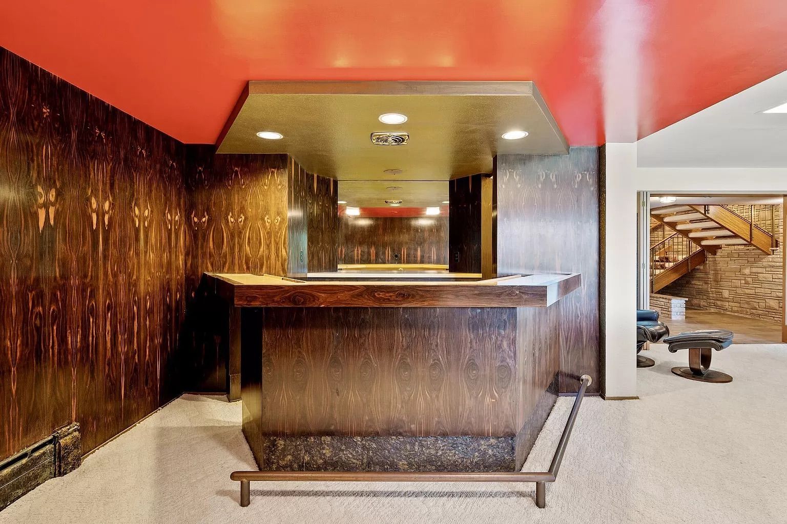 A wet bar with wood paneling.