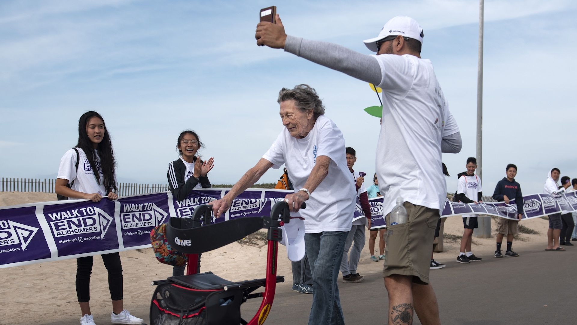 HUNTINGTON BEACH, CA - OCTOBER 06: A man records the 2-mile Walk to End Alzheimer's finish in Huntington Beach, Calif.