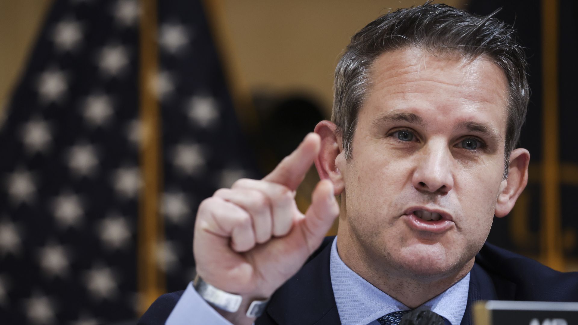 Photo of Adam Kinzinger speaking while raising a finger in the air