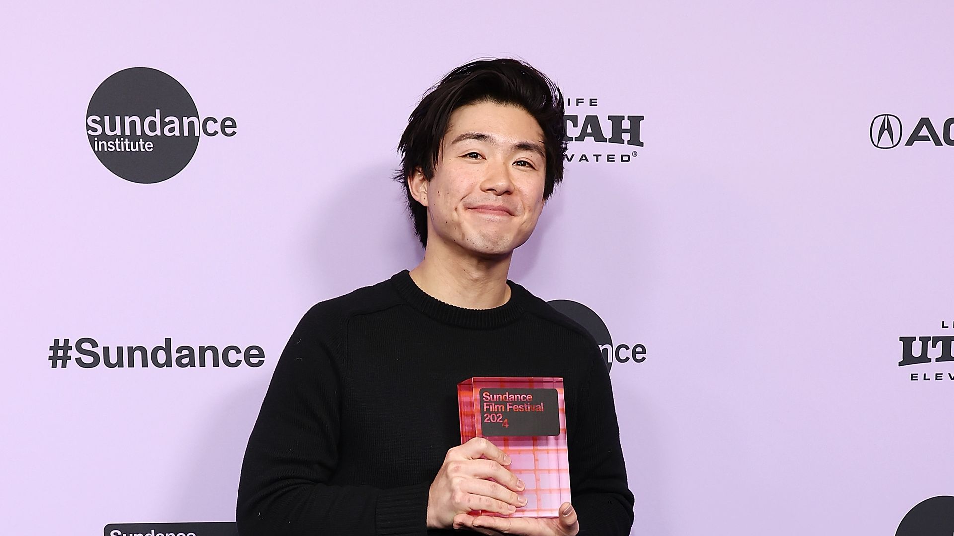 photo of a young man holding an award