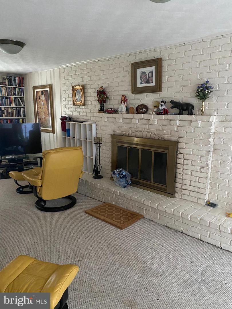 A living room with white brick and a yellow chair.