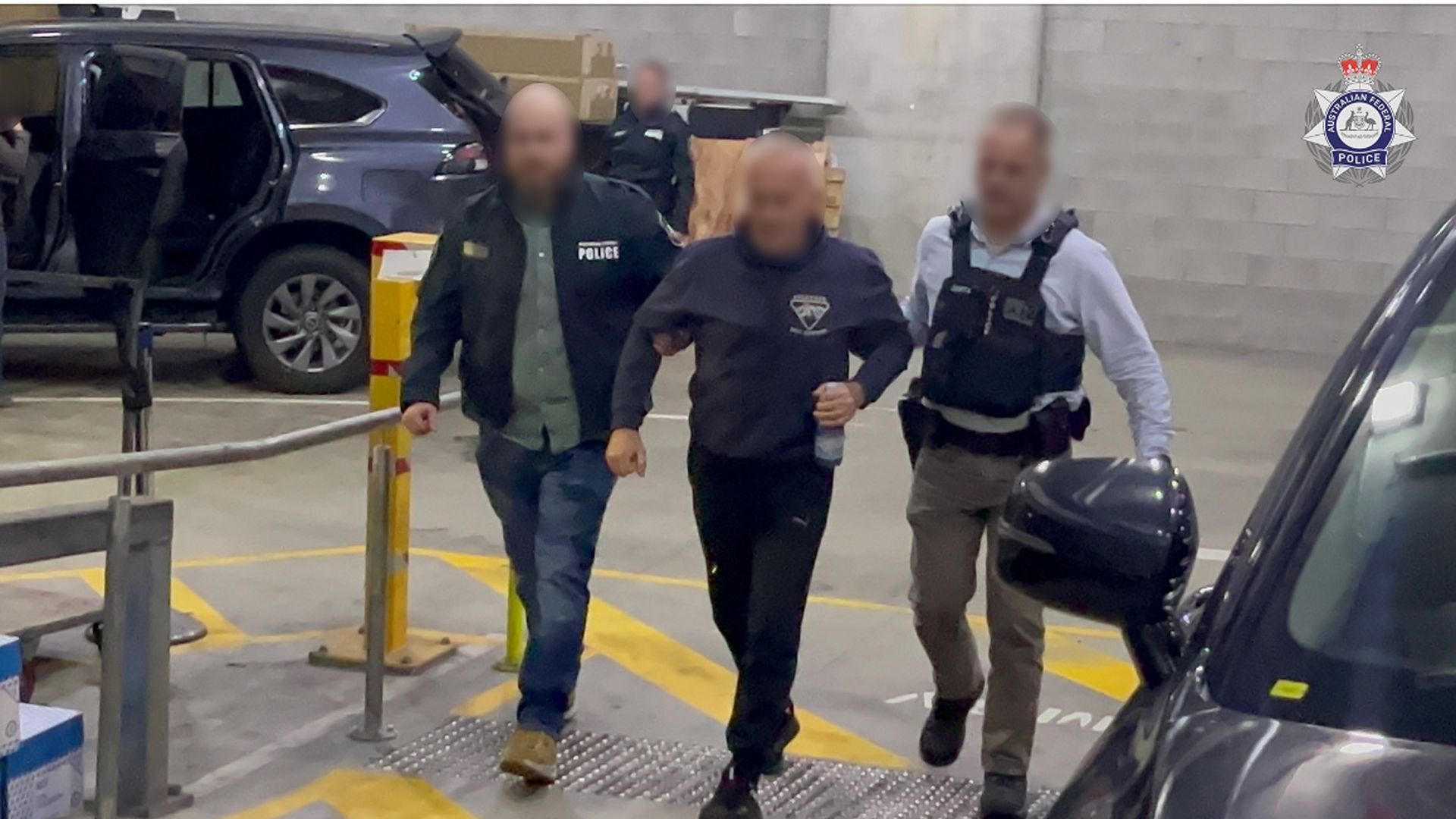 Australian Federal Police officers escort a Russian-born man arrested on suspicion of spying for Russia. 