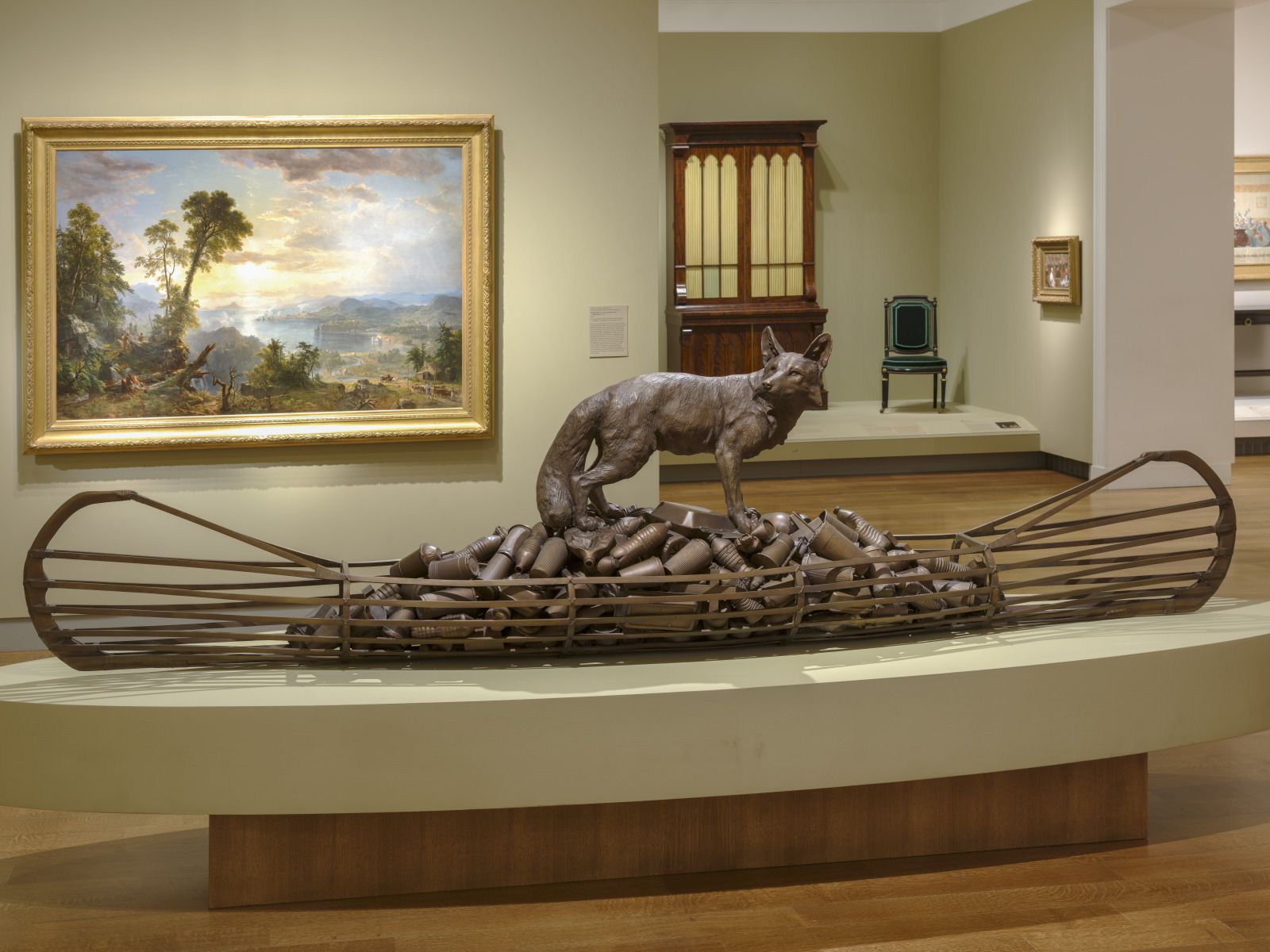 The sculpture includes two reoccurring motifs in Smith’s practice: the canoe and the trickster figure of Coyote. In Making Medicine, Coyote stands atop a pile of refuse held within the canoe, mostly made up of bronze casts of plastic water bottles and Styrofoam cups from fast-food restaurants.