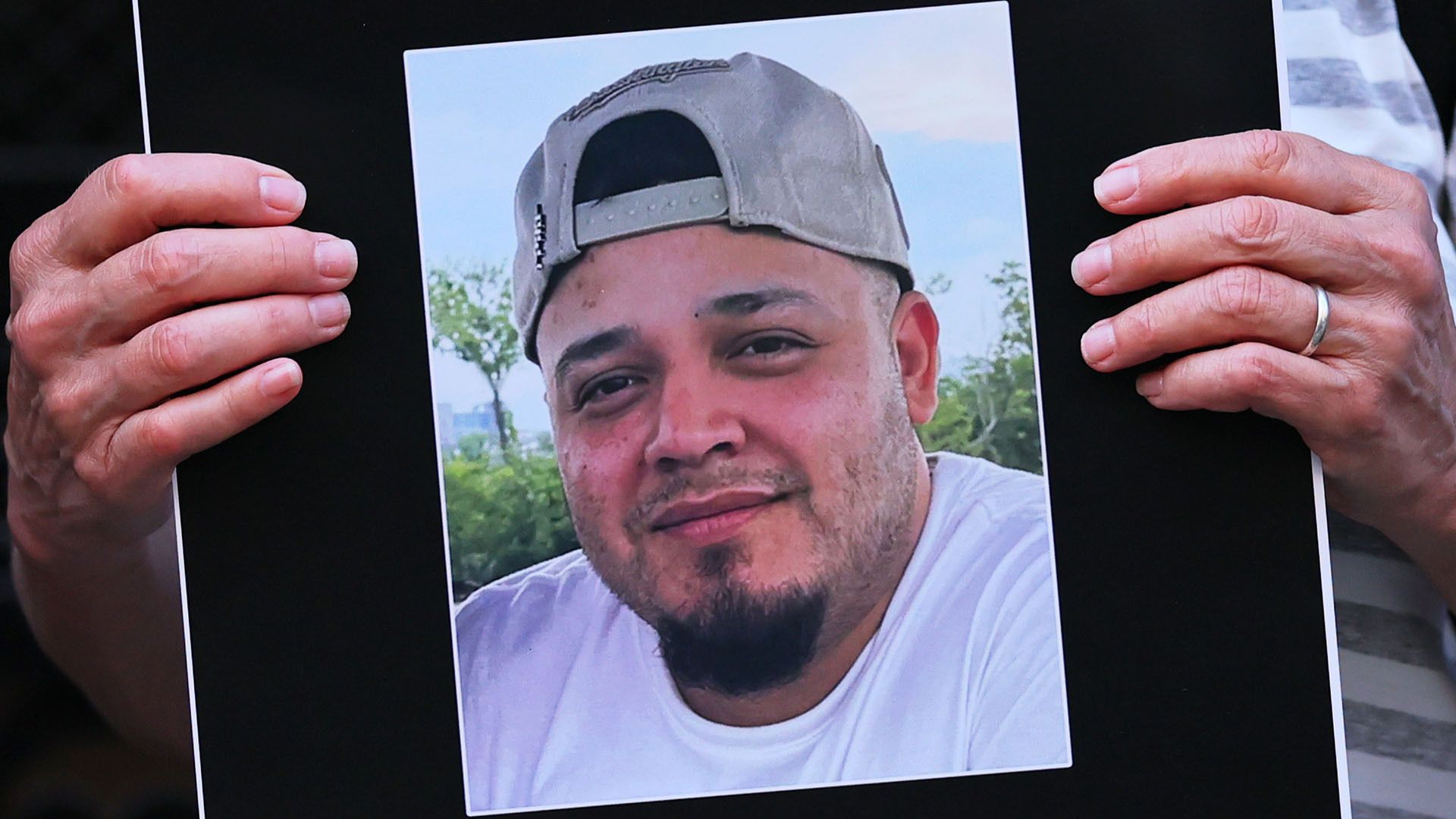 A person holds a photo of Kilmar Abrego Garcia.