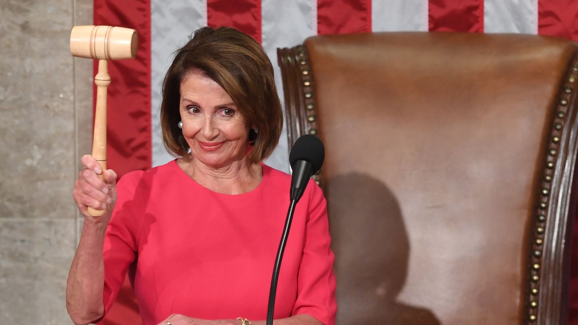 In this image, Pelosi holds a gavel up. 