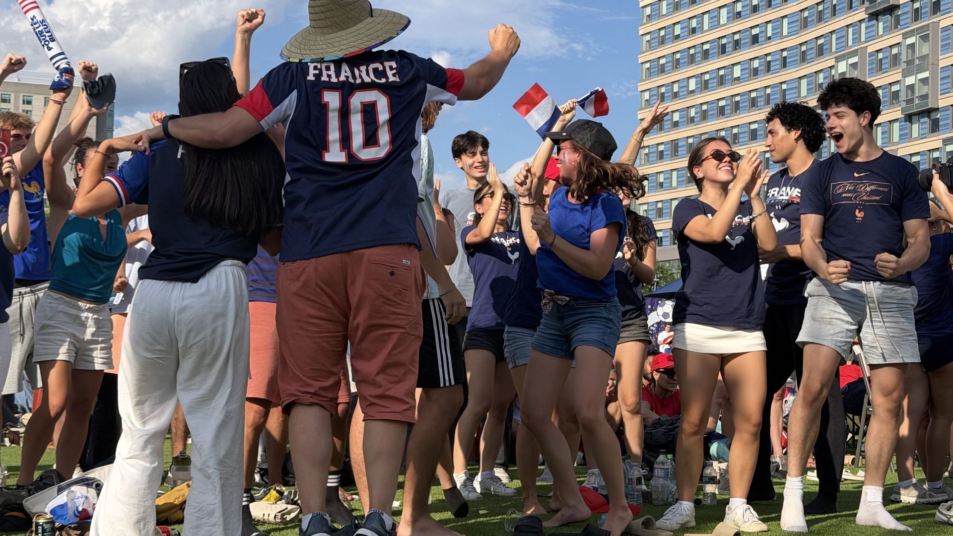Fans of the France national team in Boston stand, wave flags and cheer at the Lawn on D  after France first scored against Morocco during the July 9, 2026, quarterfinals World Cup match.