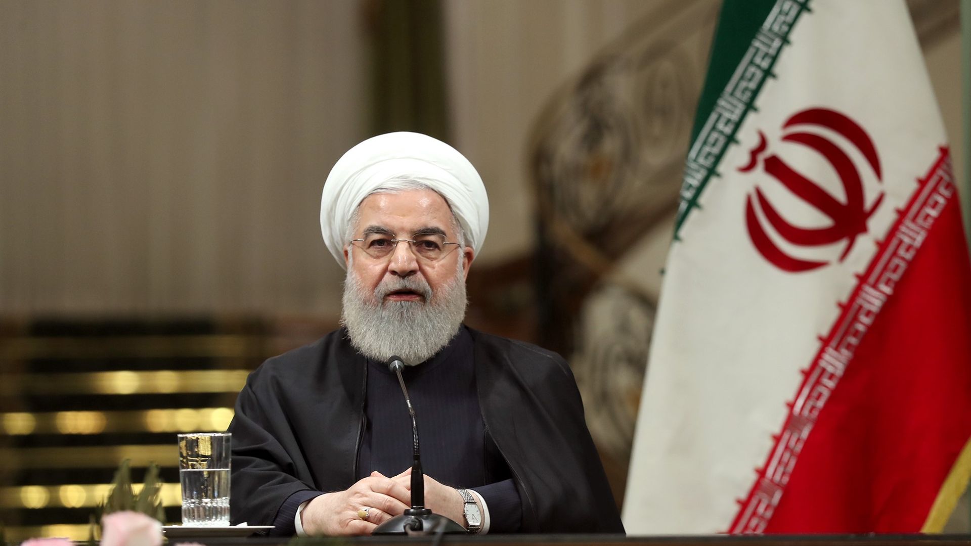 Hassan Rouhani seated at a press conference