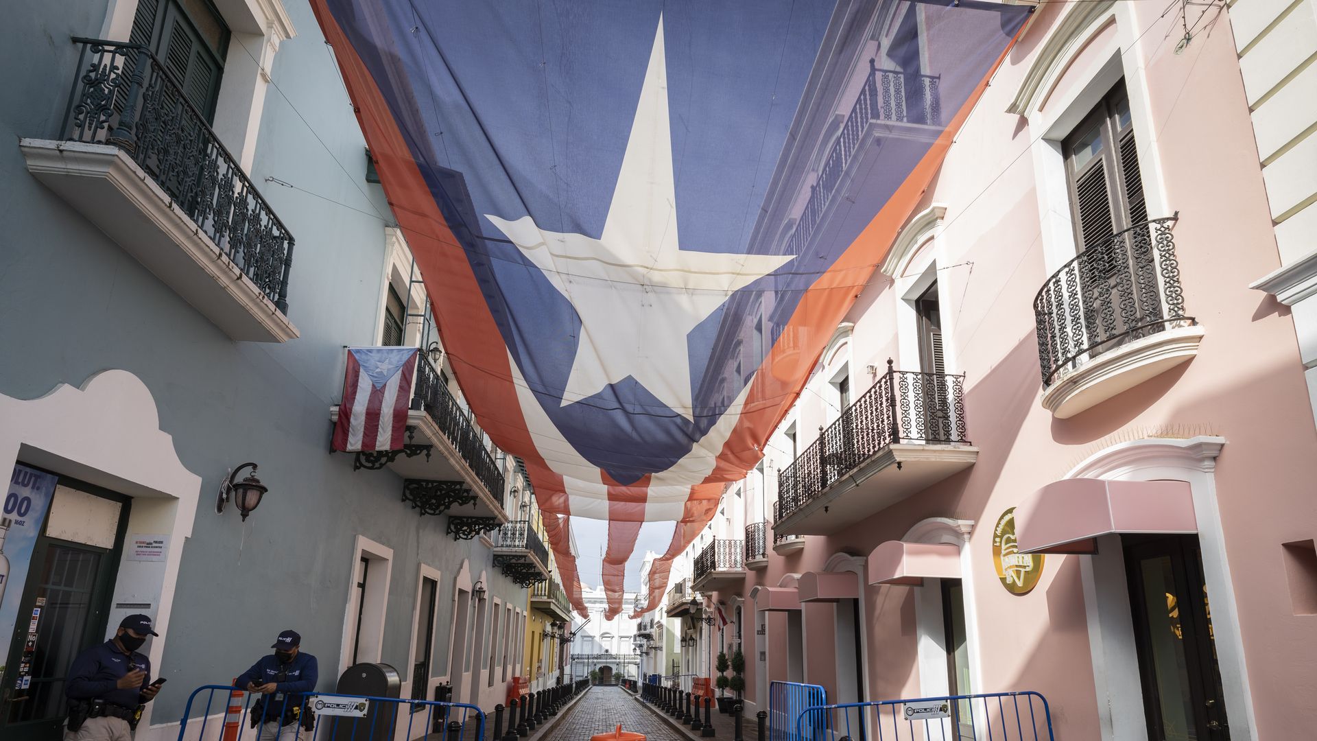 Photo of a giant banner of the Puerto Rican flag hanging between two buildings