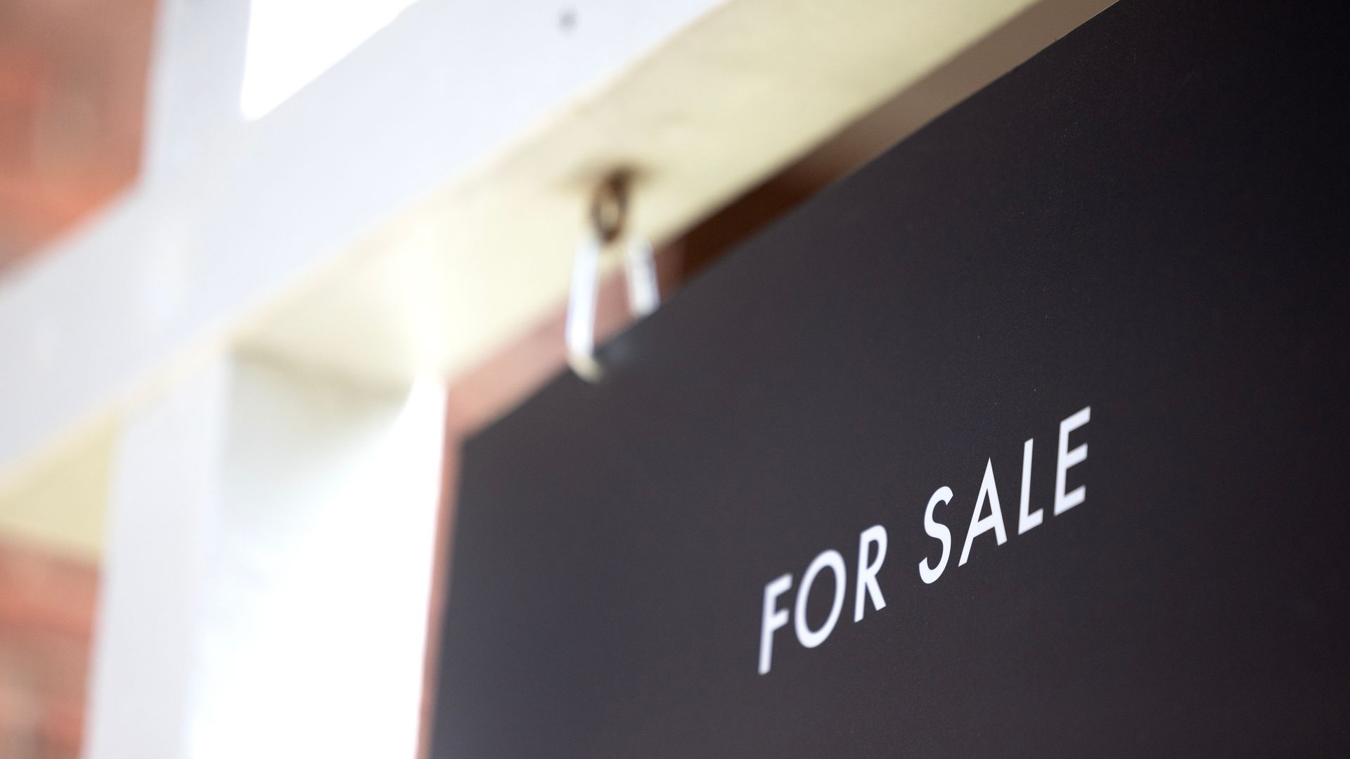 A photo showing a "For sale" sign outside a home.
