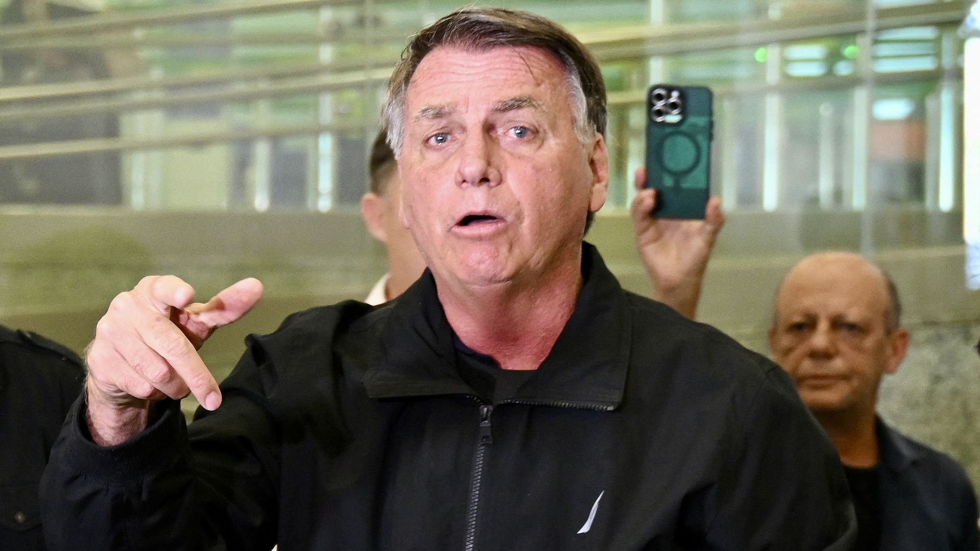 Former Brazilian President Jair Bolsonaro gestures after accompanying his wife, Michelle Bolsonaro, to board a plane bound for the US to represent him in President-elect Donald Trump's inauguration after a Brazilian judge denied his request to travel at Brasilia airport on January 18, 2025.