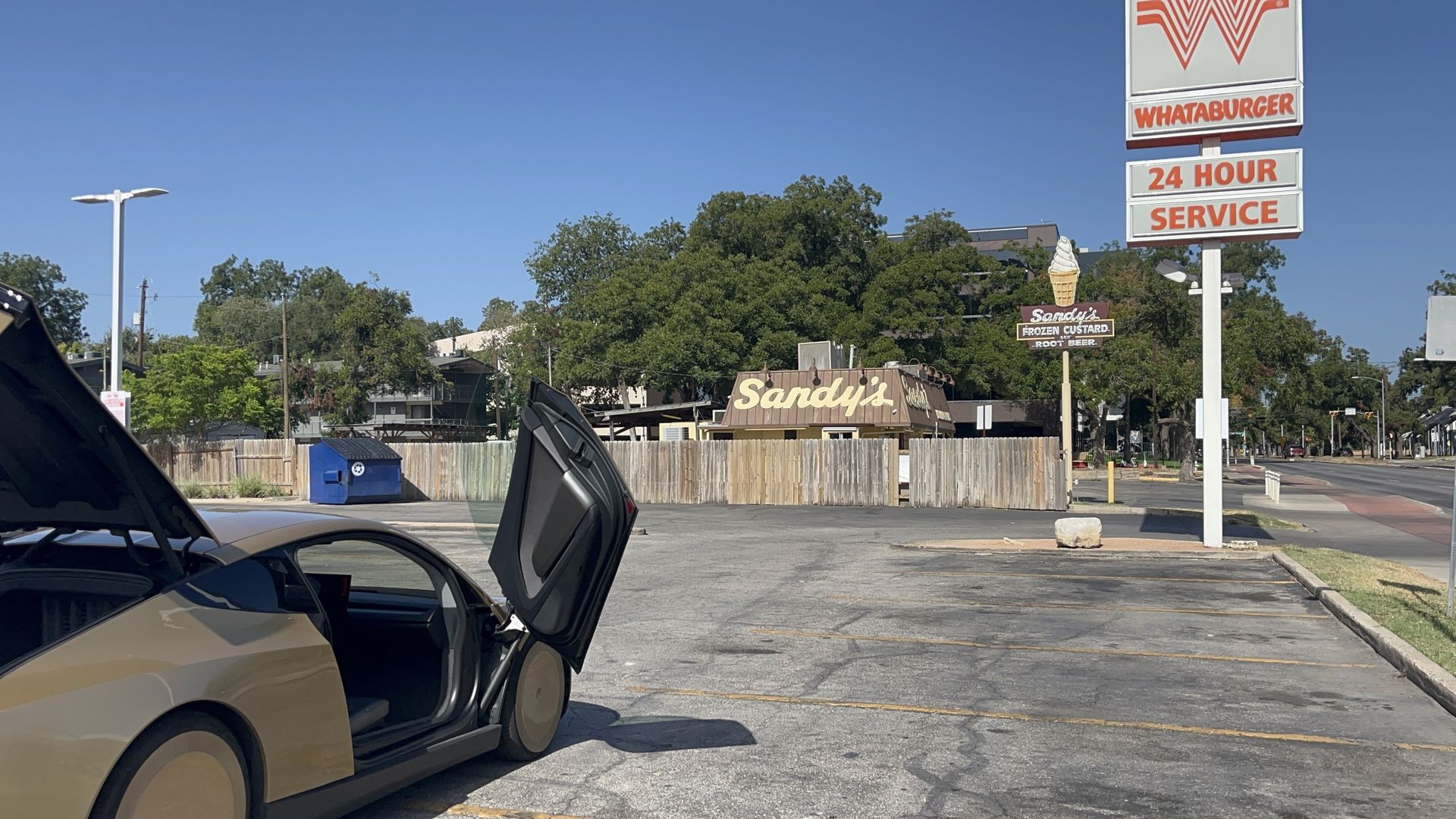 A Tesla robotaxi, stopped in a Whatburger parking lot.