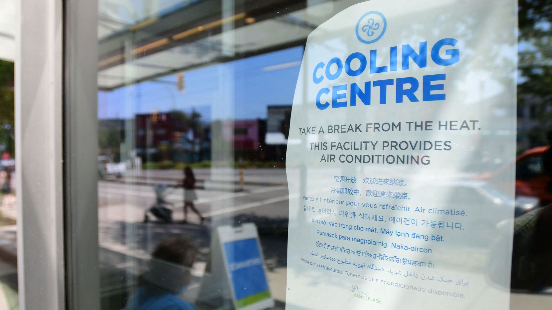 Photo of a paper sign that says "Cooling Centre" taped to a glass wall