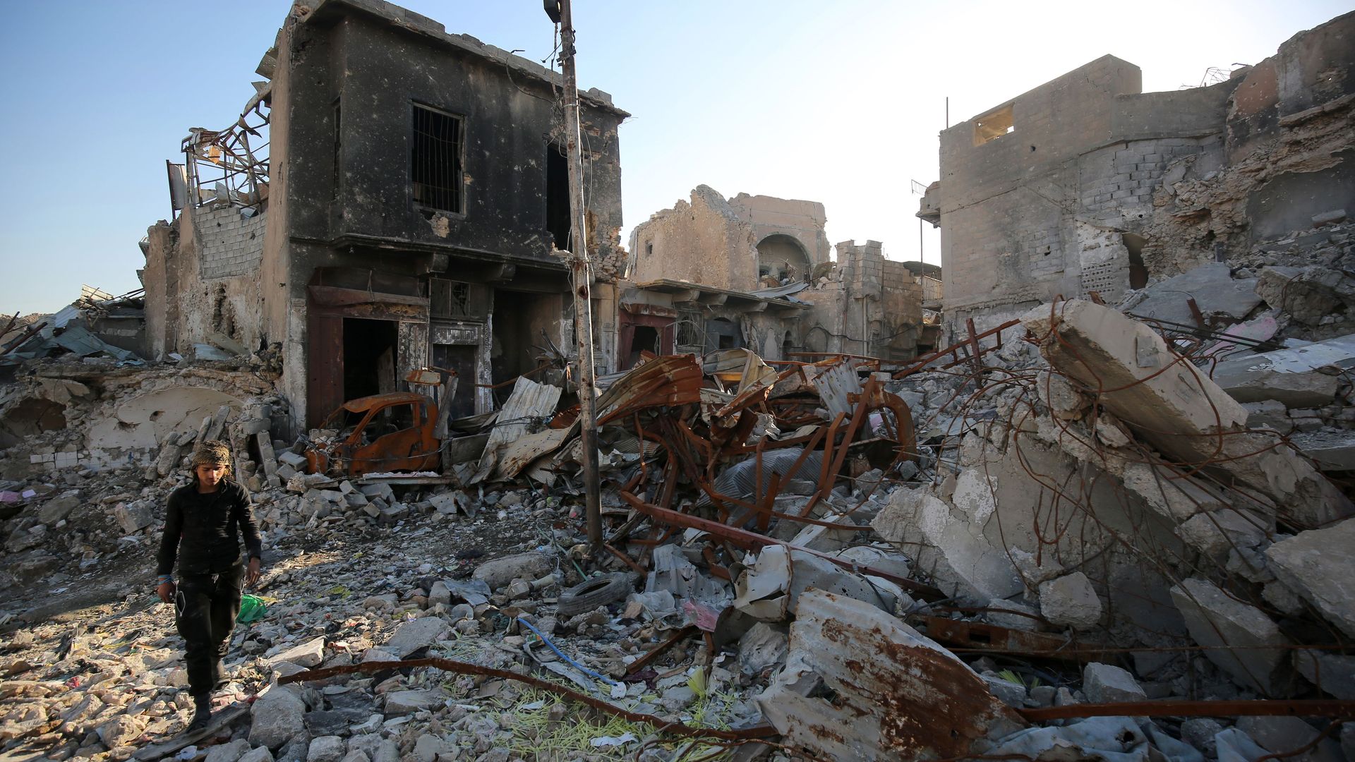 An Iraqi man walks over the rubble in the old city of Mosul.