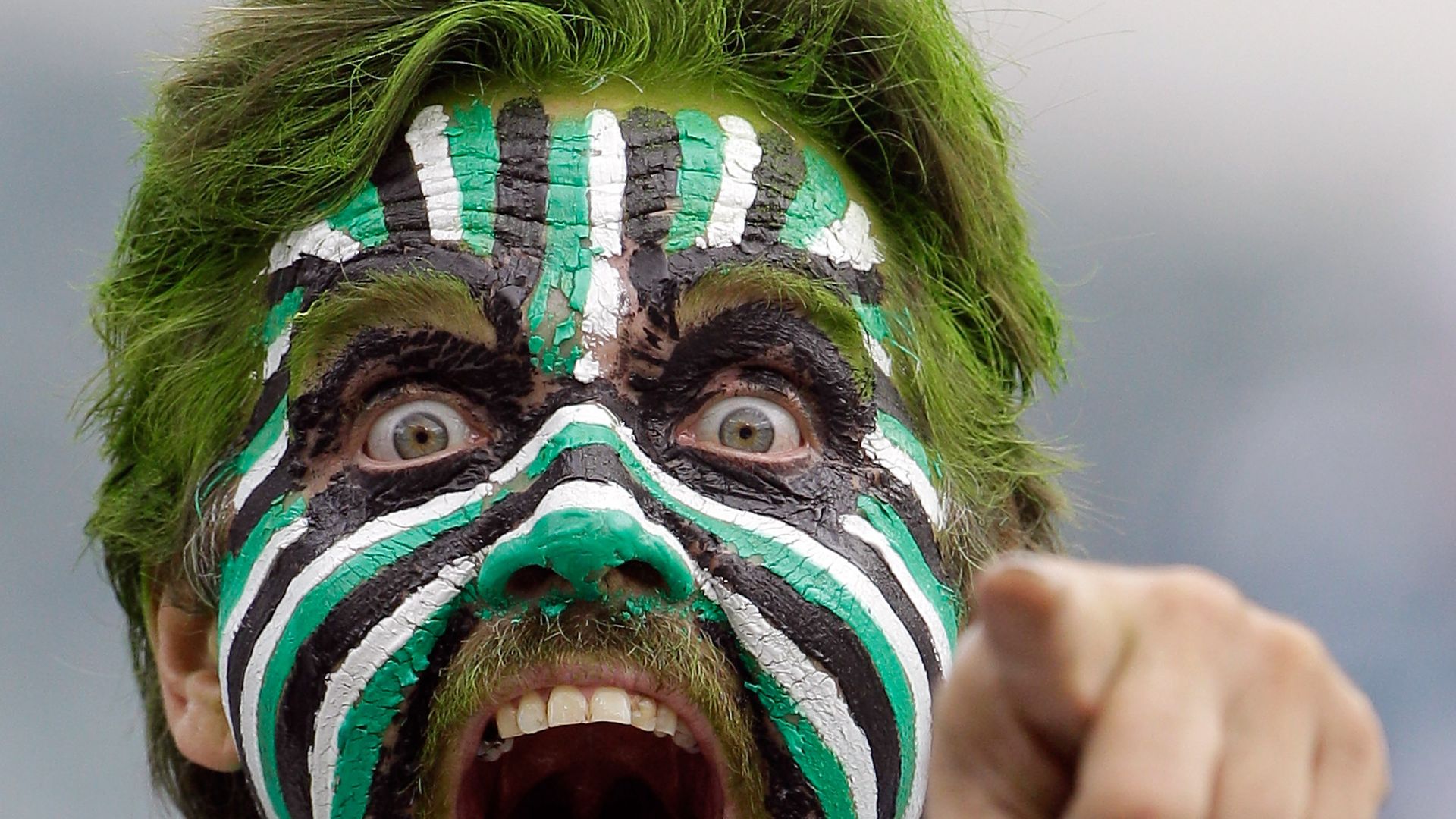A tongue-wagging Philadelphia Eagles fan pointing and cheering.