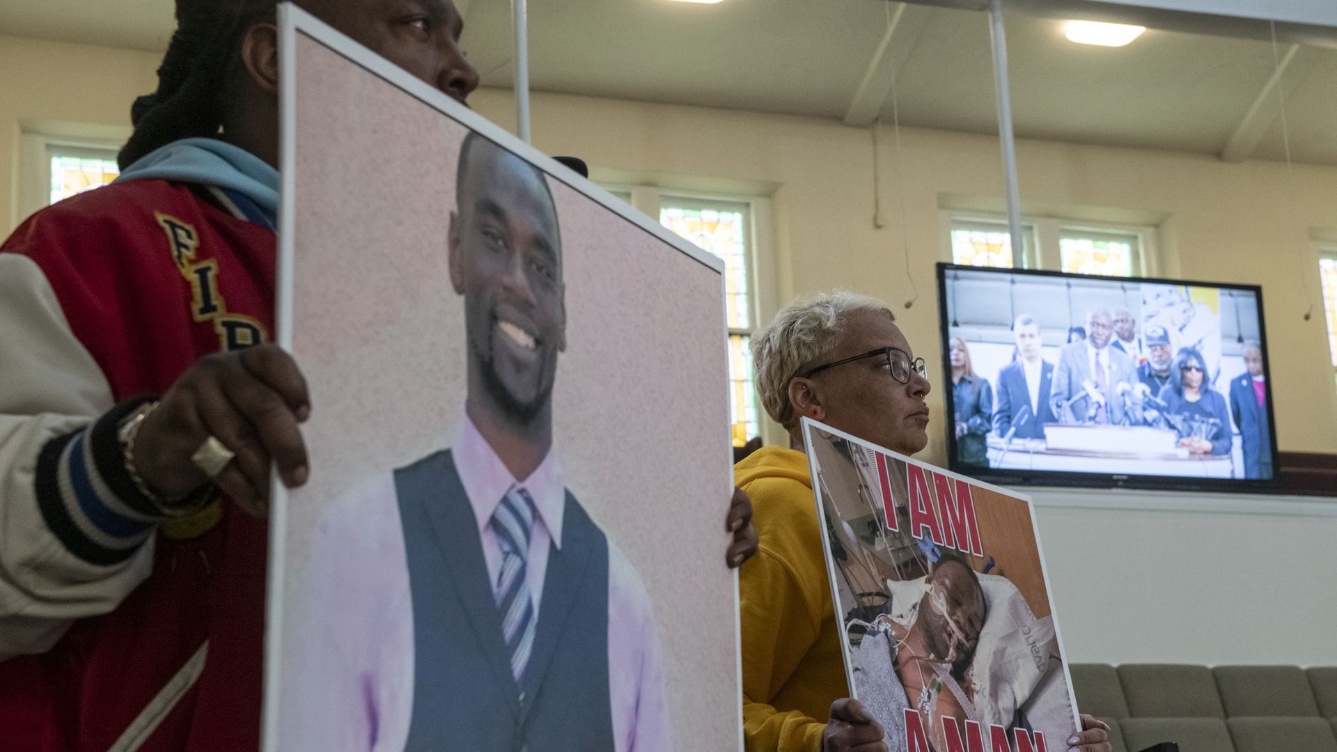 People holding signs showing Tyre Nichols in a church in Memphis, Tennessee, on Jan. 23.