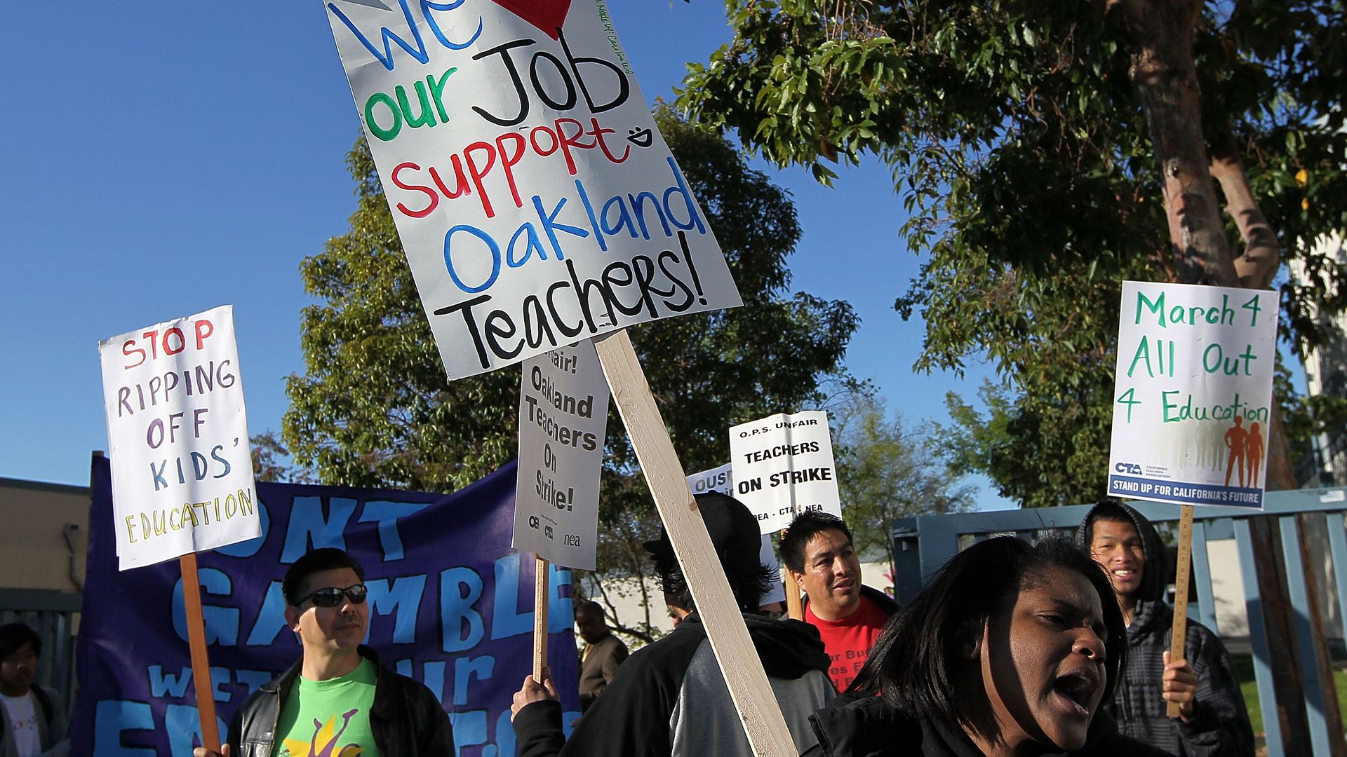 Teachers and students hold signs as they protest during a one-day strike outside of Oakland High School April 29, 2010 in Oakland, California.