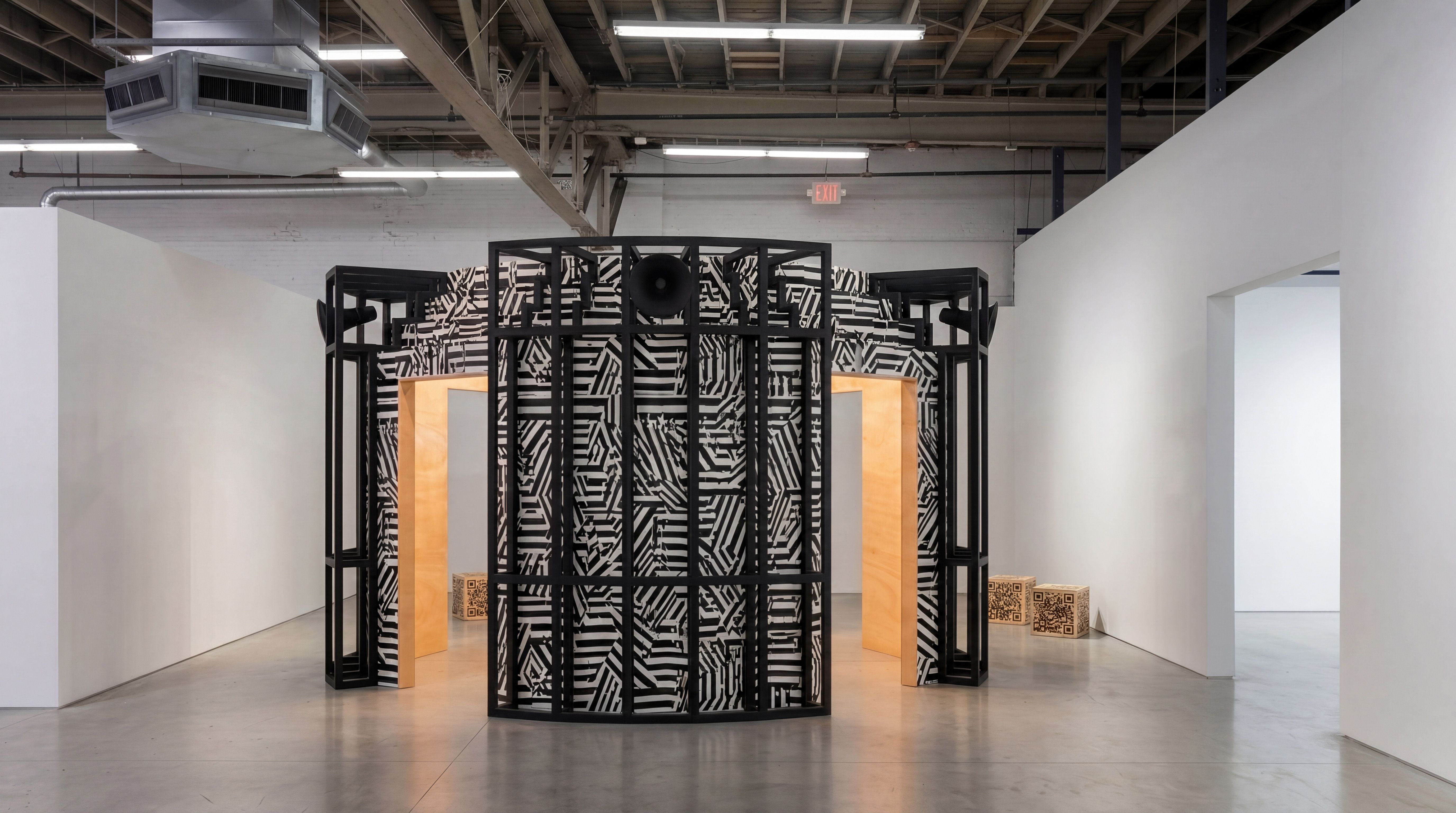 A large black and white installation with what looks like cameras or a sound system, and a zebra-like pattern.