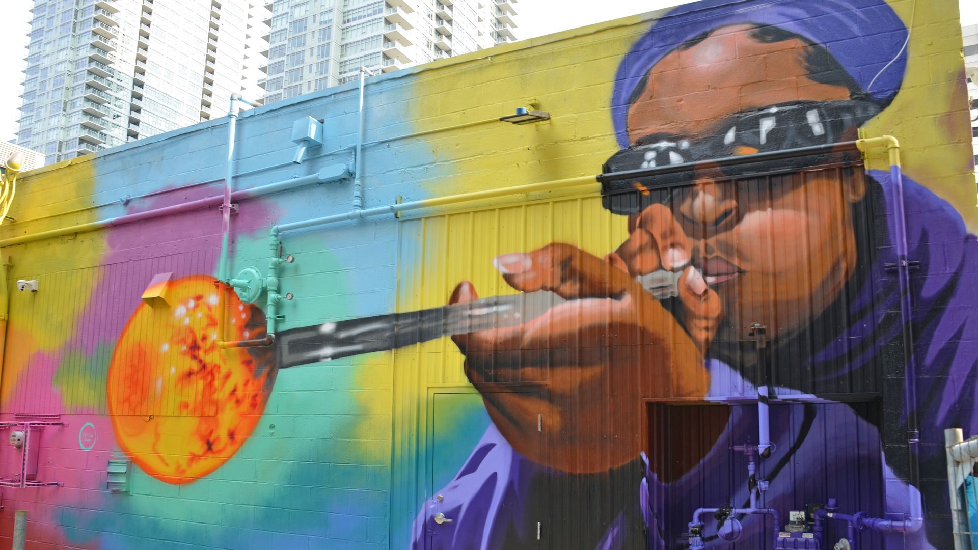 A glassblower with sunglasses creates art in a new Seattle mural. 