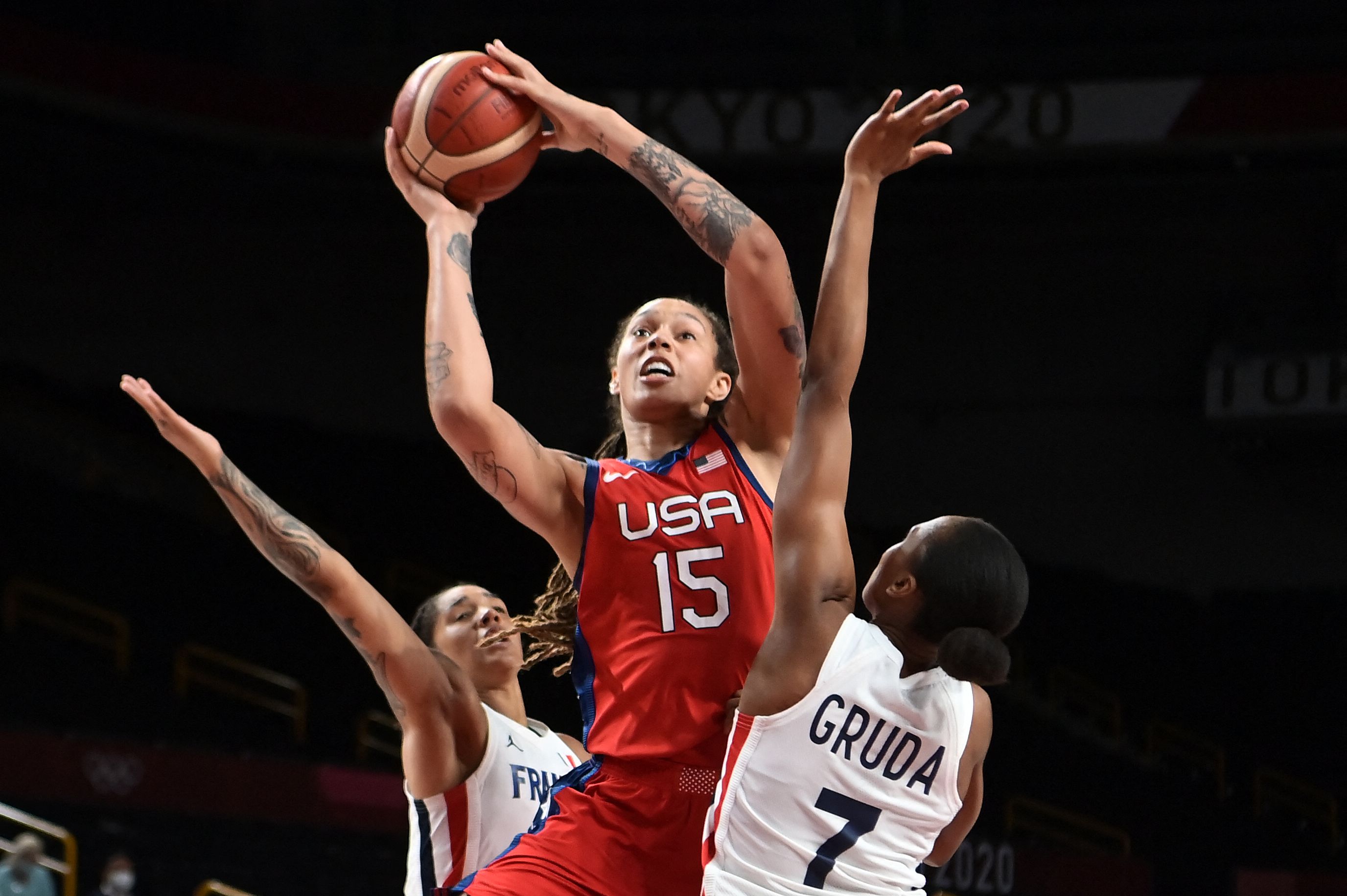 USA's Brittney Griner (C) goes to the basket past France's Sandrine Gruda (R) in the women's preliminary round group B basketball match between France and USA