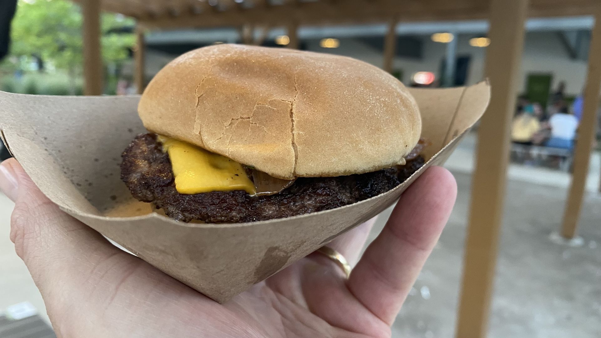 A photo of a cheeseburger in a paper boat.