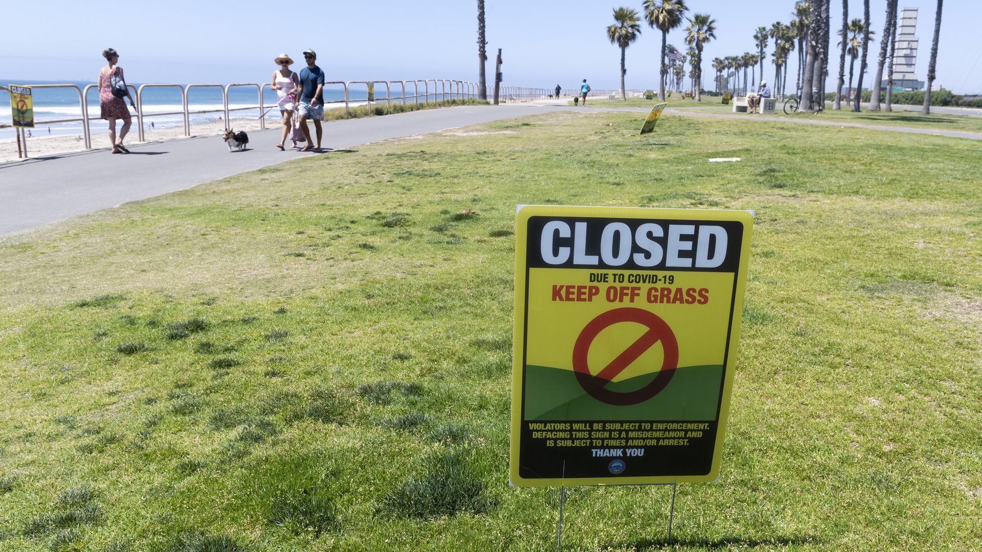 The beach and walkways are open but the grass is closed in Huntington, Calif.