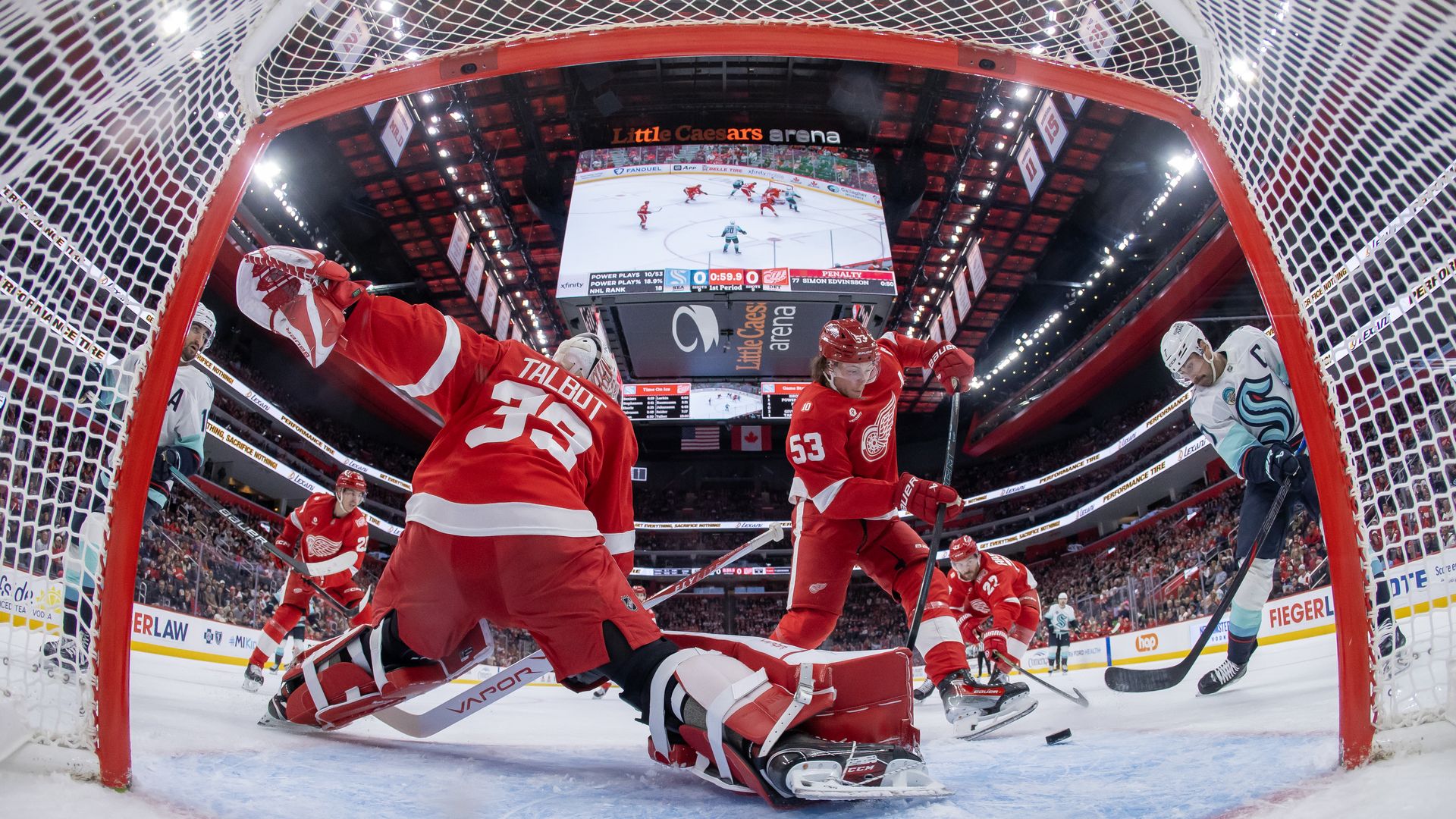 View from inside the net as Jordan Eberle of the Seattle Kraken scores a goal on Cam Talbot of the Detroit Red Wings.