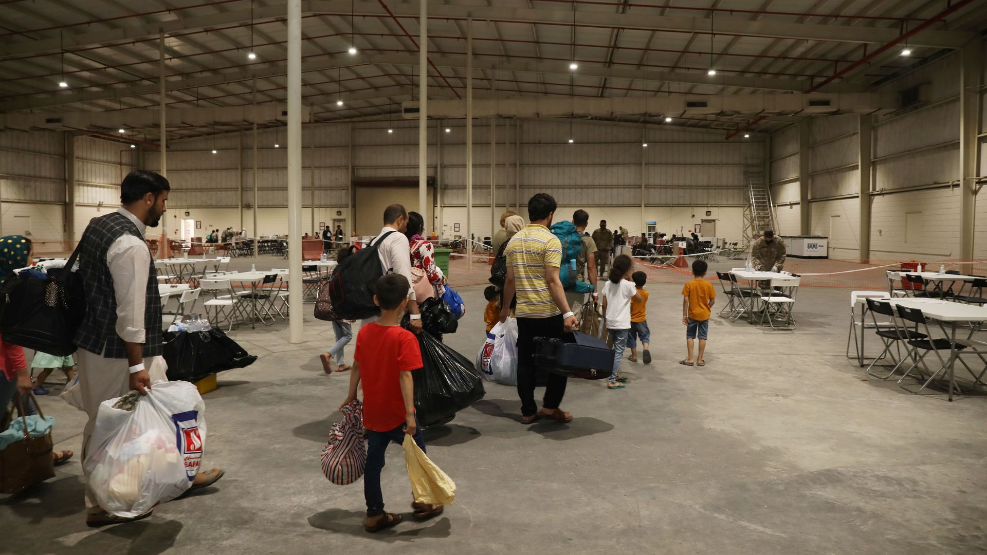 Afghan refugees are seen walking through a holding station in Qatar last August.