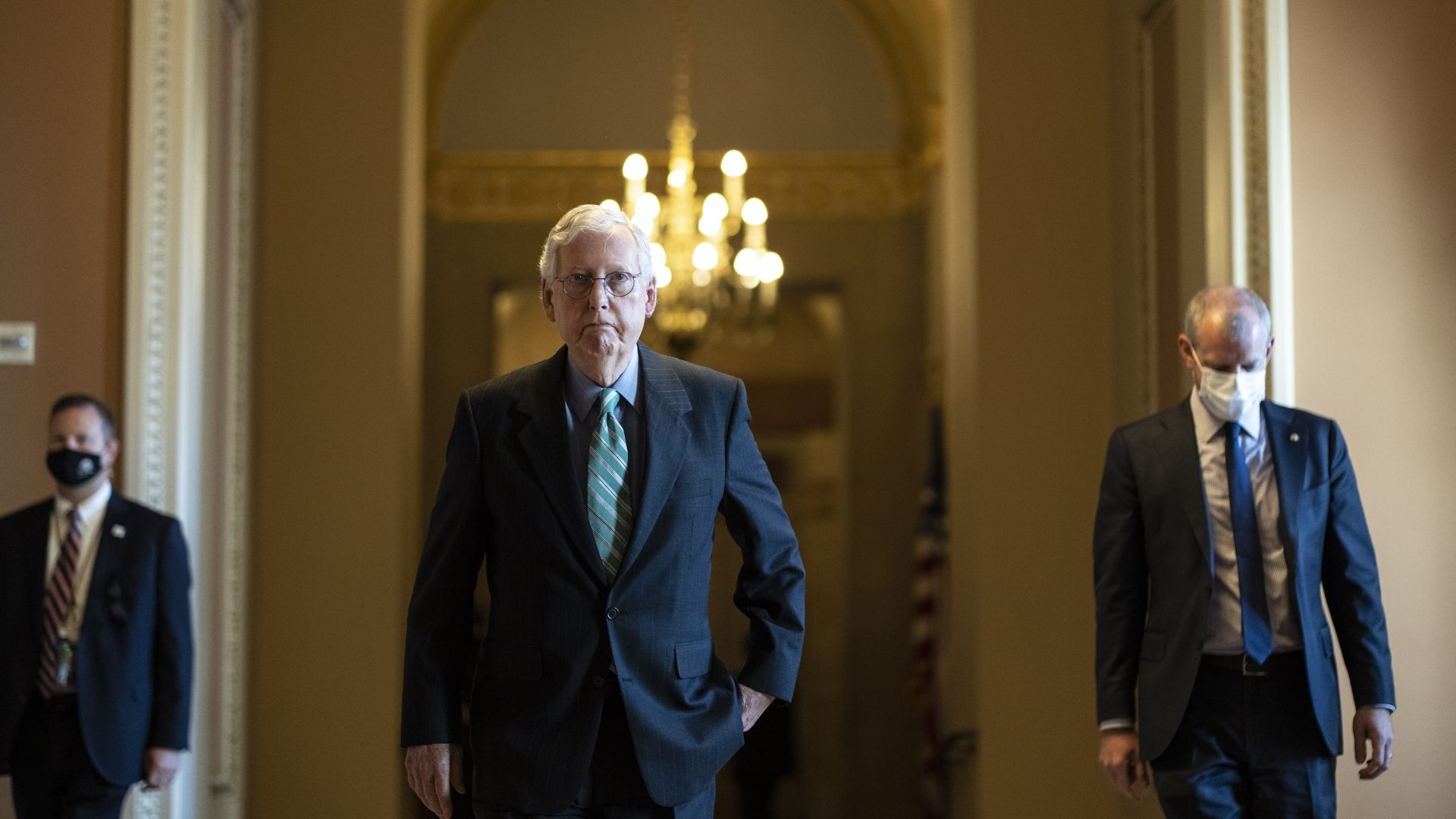 Photo of Mitch McConnell walking the halls of the Capitol with one hand in his pocket
