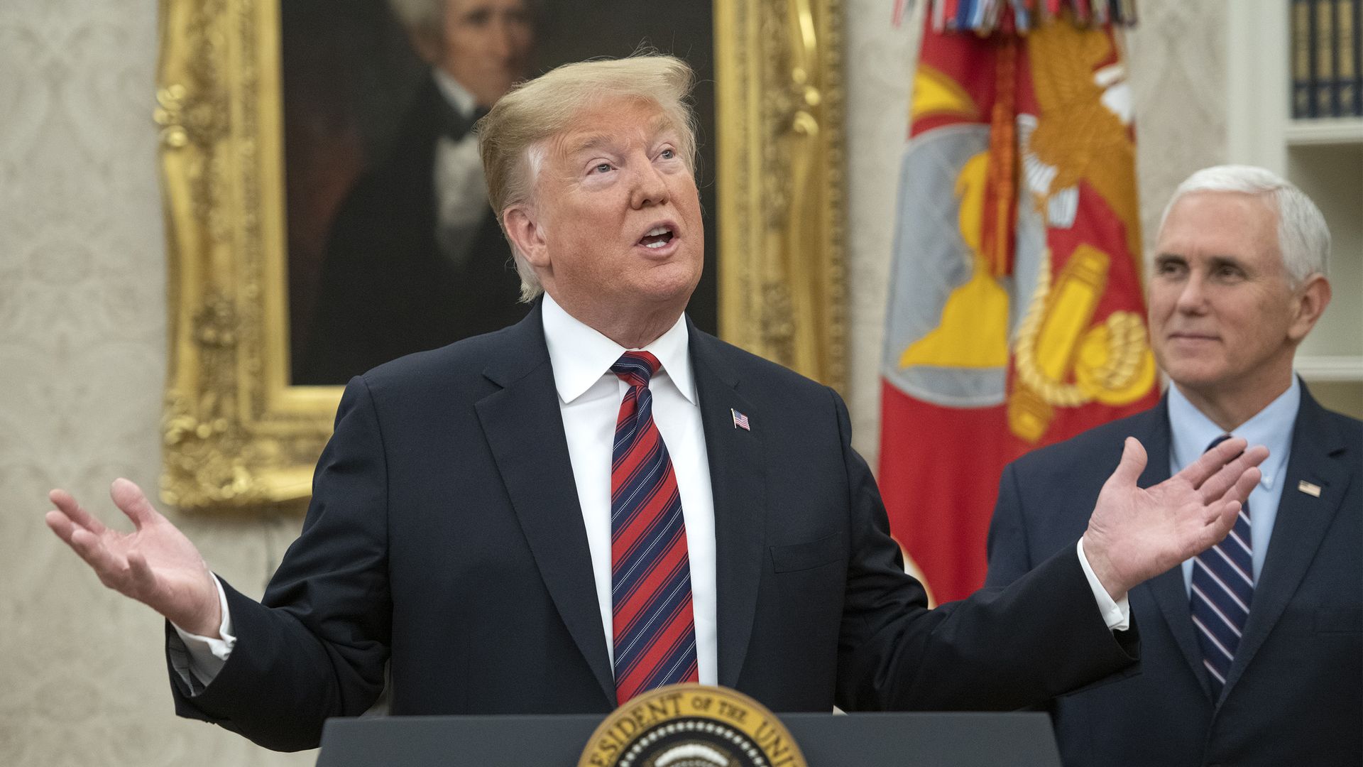 Donald Trump making a speech with both of his hands out to the side and looking slightly up
