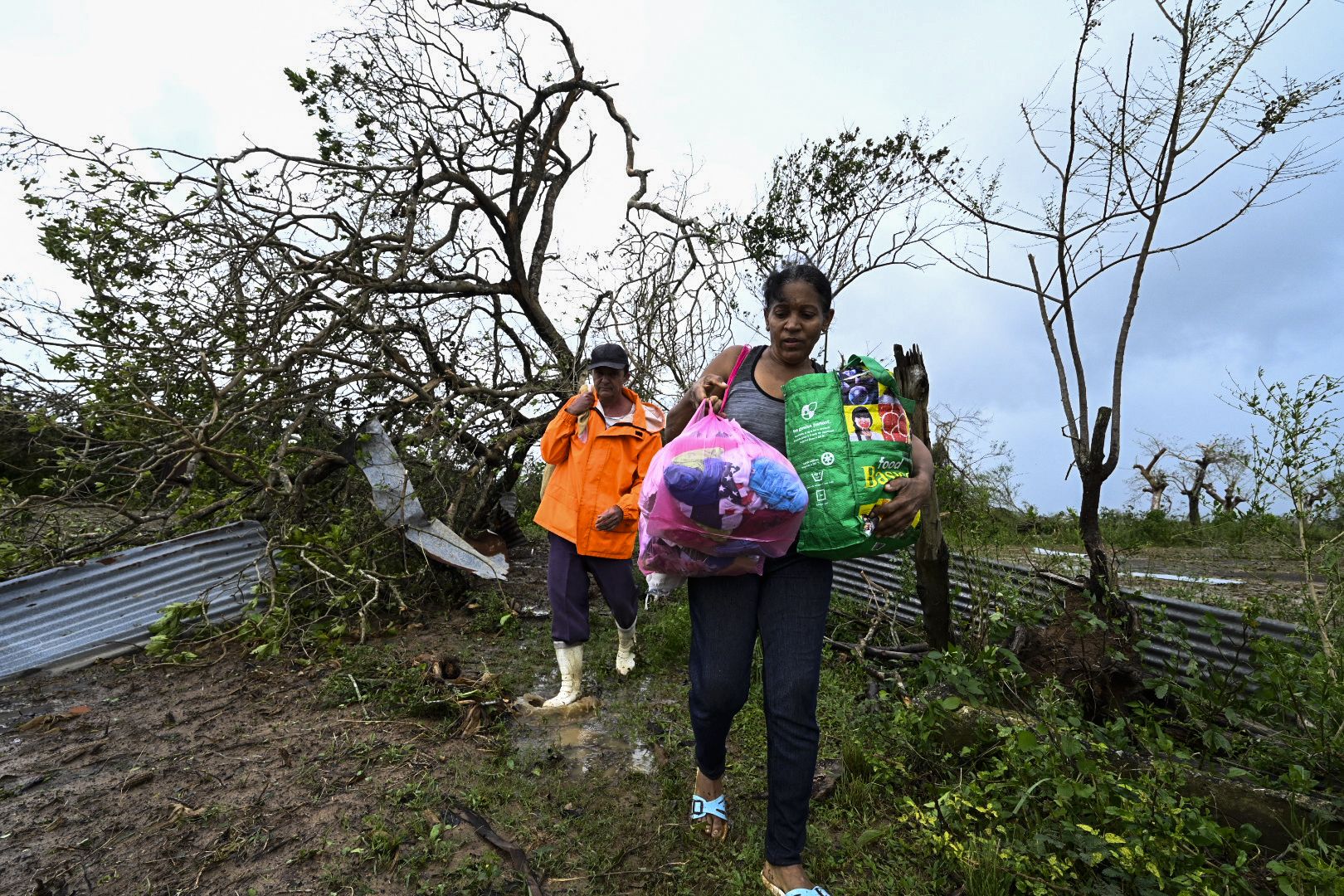 distraught people carrying supplies during a hurricane