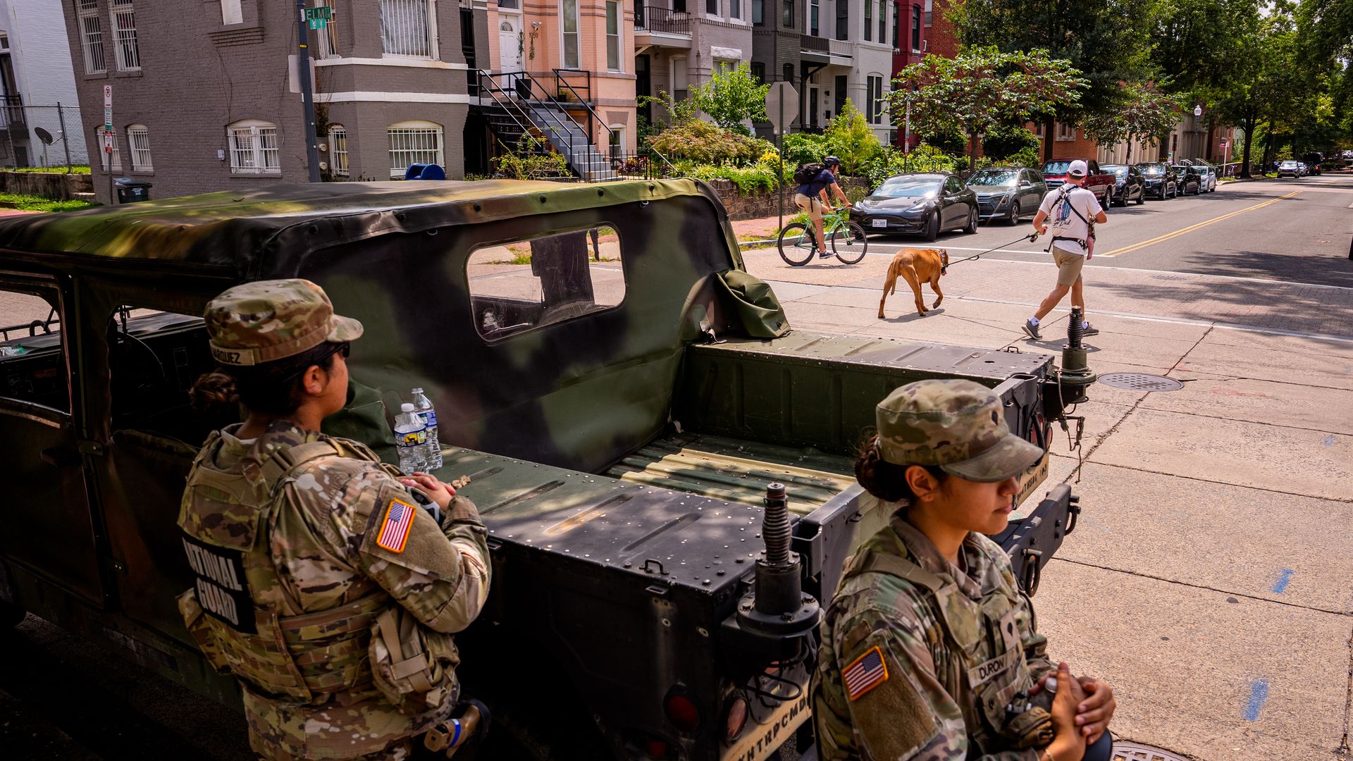 National Guard members stand next to a military vehicle on a D.C. neighborhood block