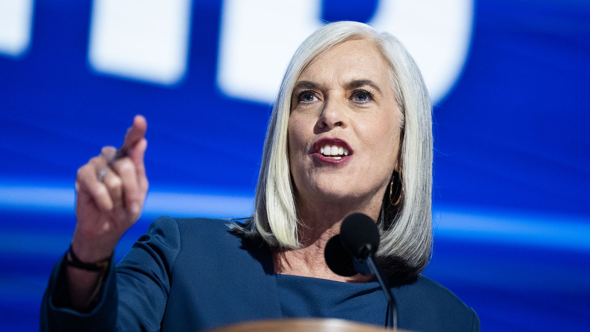 House Democratic Whip Katherine Clark, wearing a blue suit and speaking at a podium.