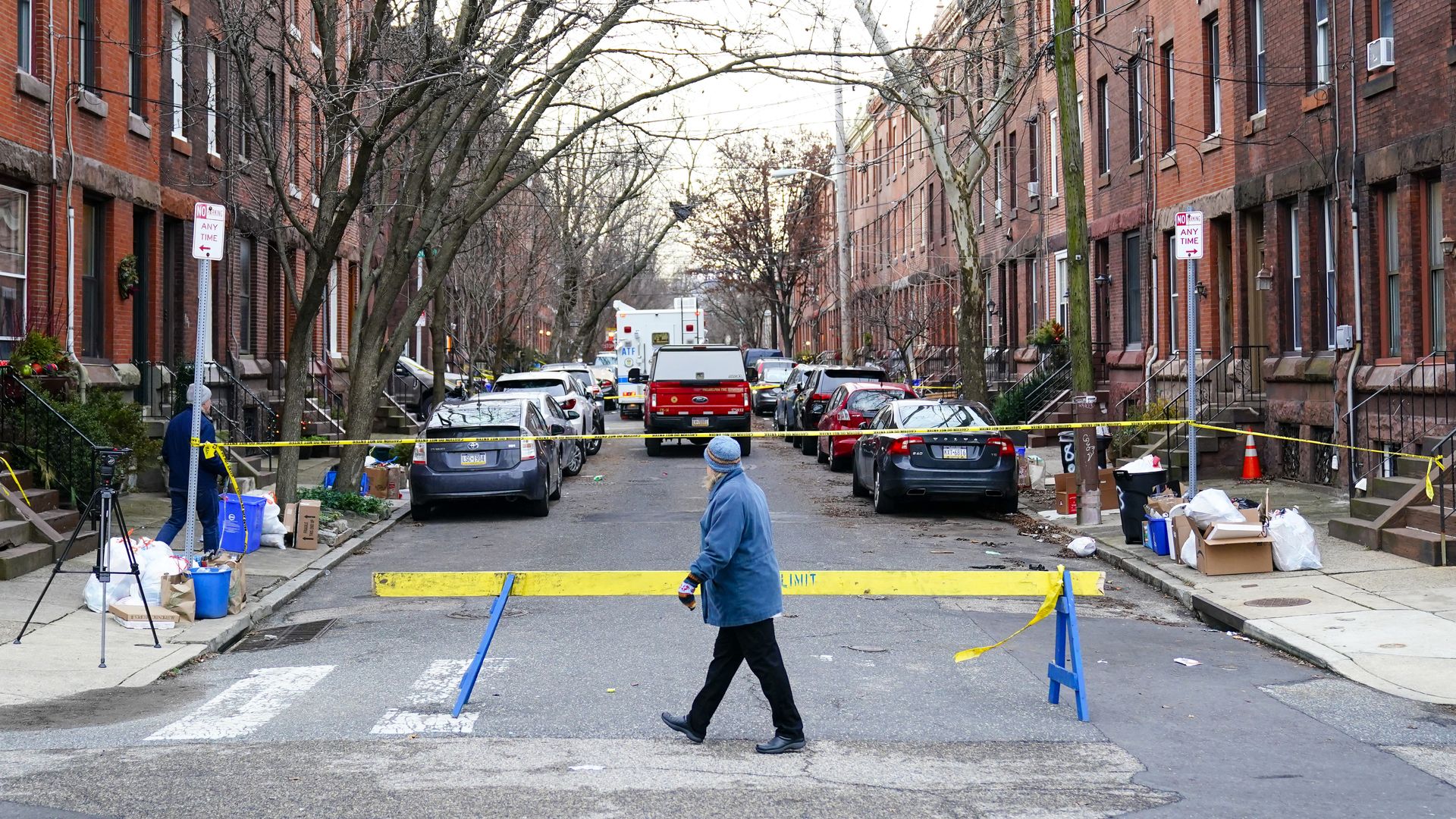 A passer-by looks over the barricade on the street of Wednesday's deadly fire in the Fairmount neighborhood of Philadelphia on Thursday.