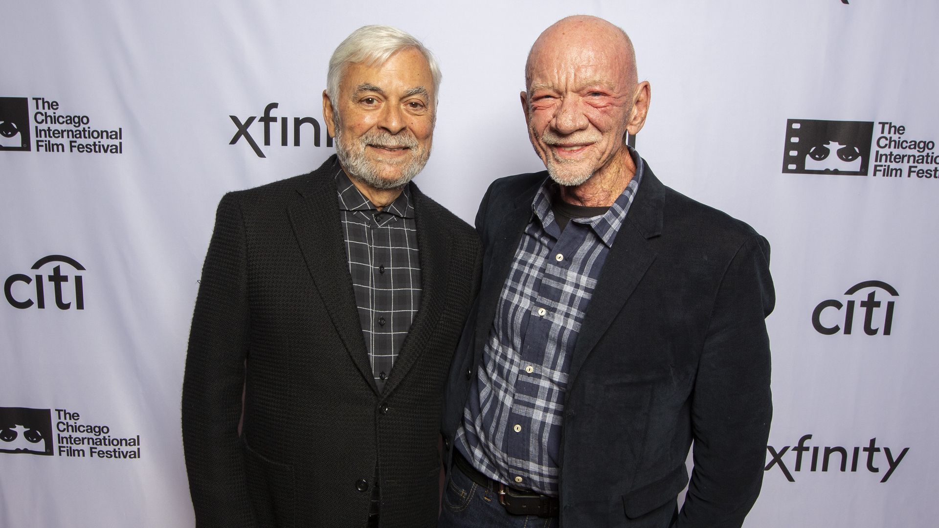 Photo of two men posing for photos on a red carpet