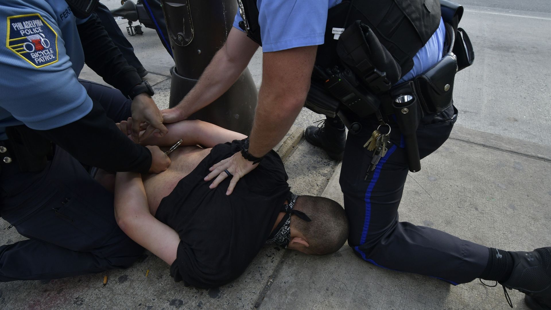 Police officers arresting someone after a police brutality protest