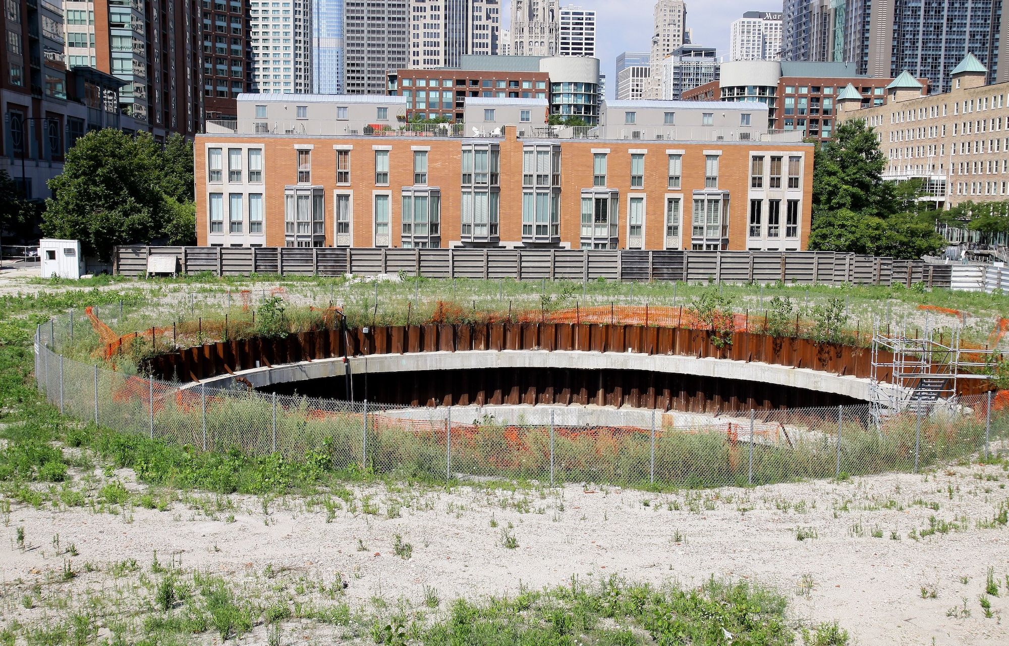 Aerial view of a huge hole in the ground in front of a residential building.