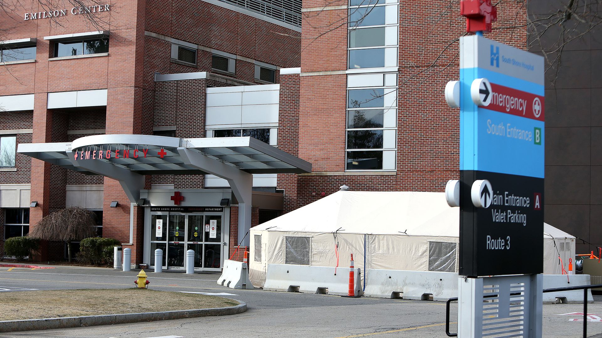 A white tent outside of a hospital emergency room.