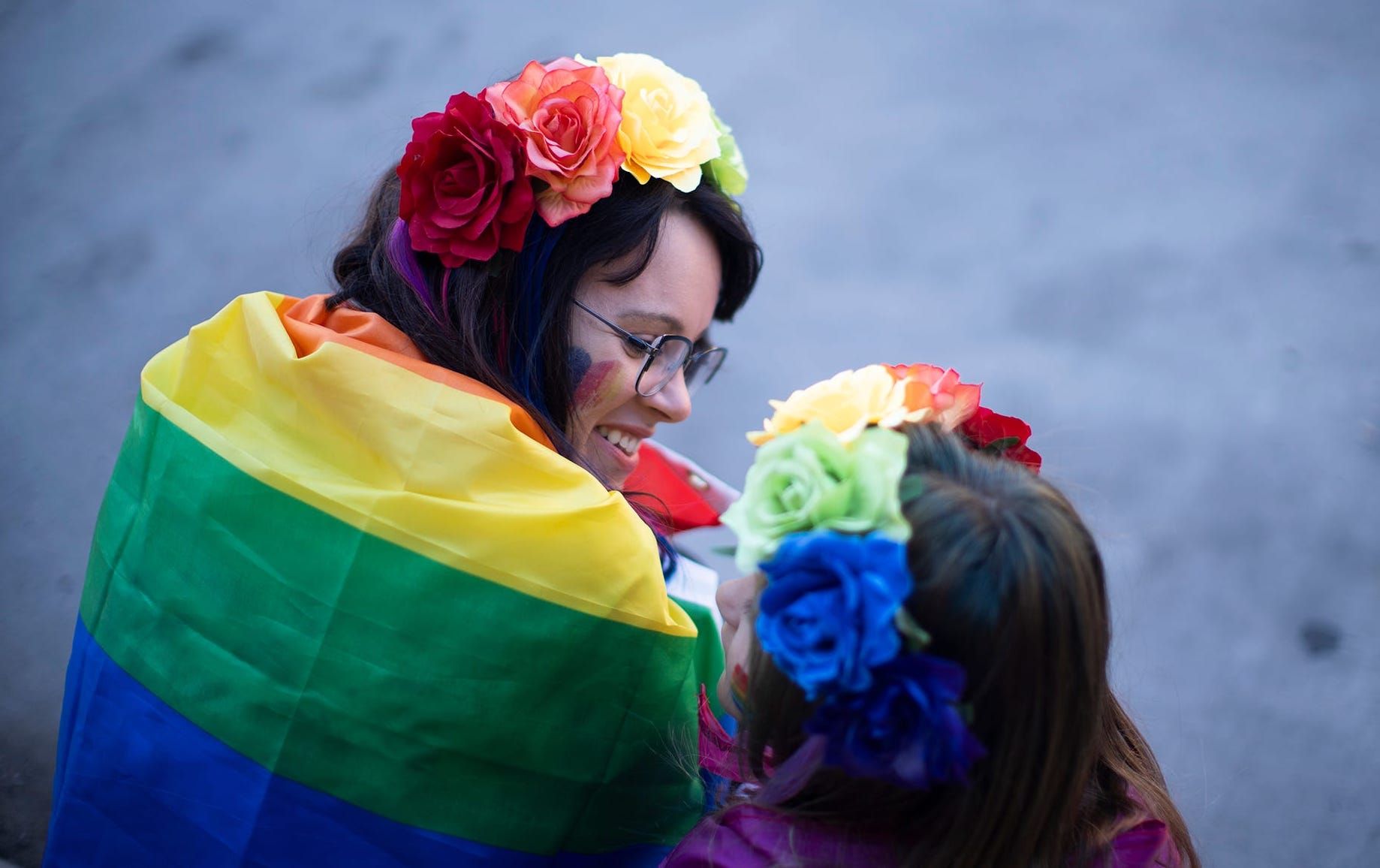 A mother and daughter in rainbow flower headbands
