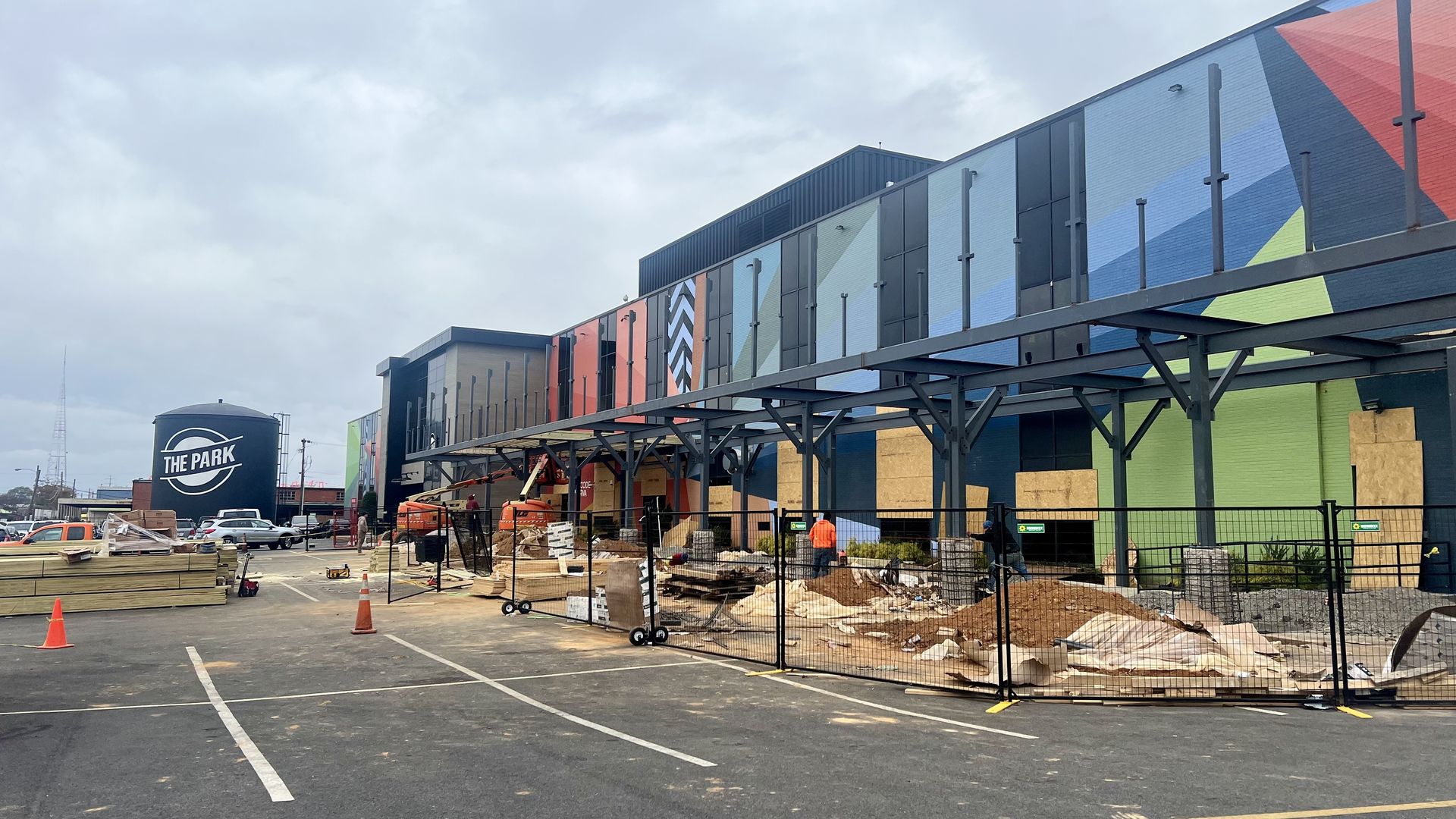 A colorful building in a parking lot with construction and orange cones in front of it.