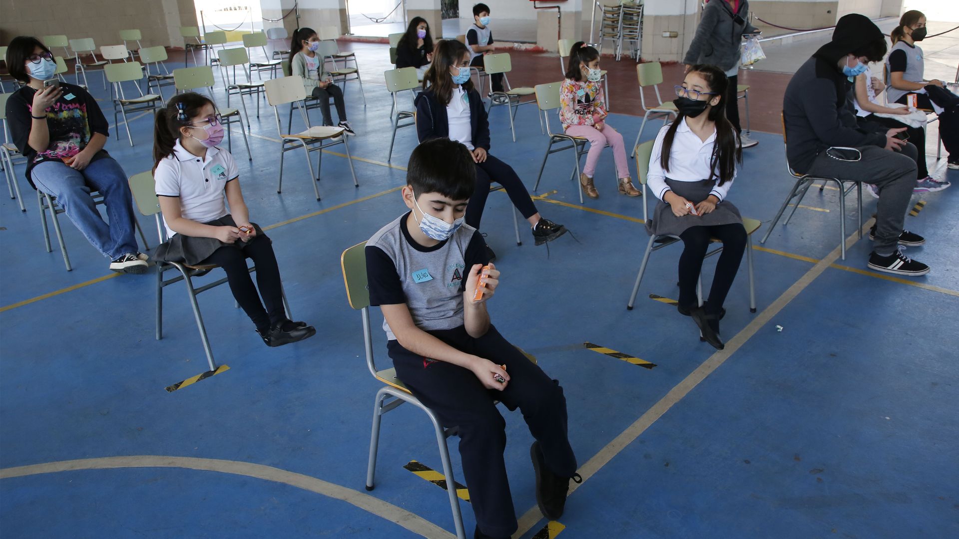 Children in Chile wait after being vaccinated against COVID-19.
