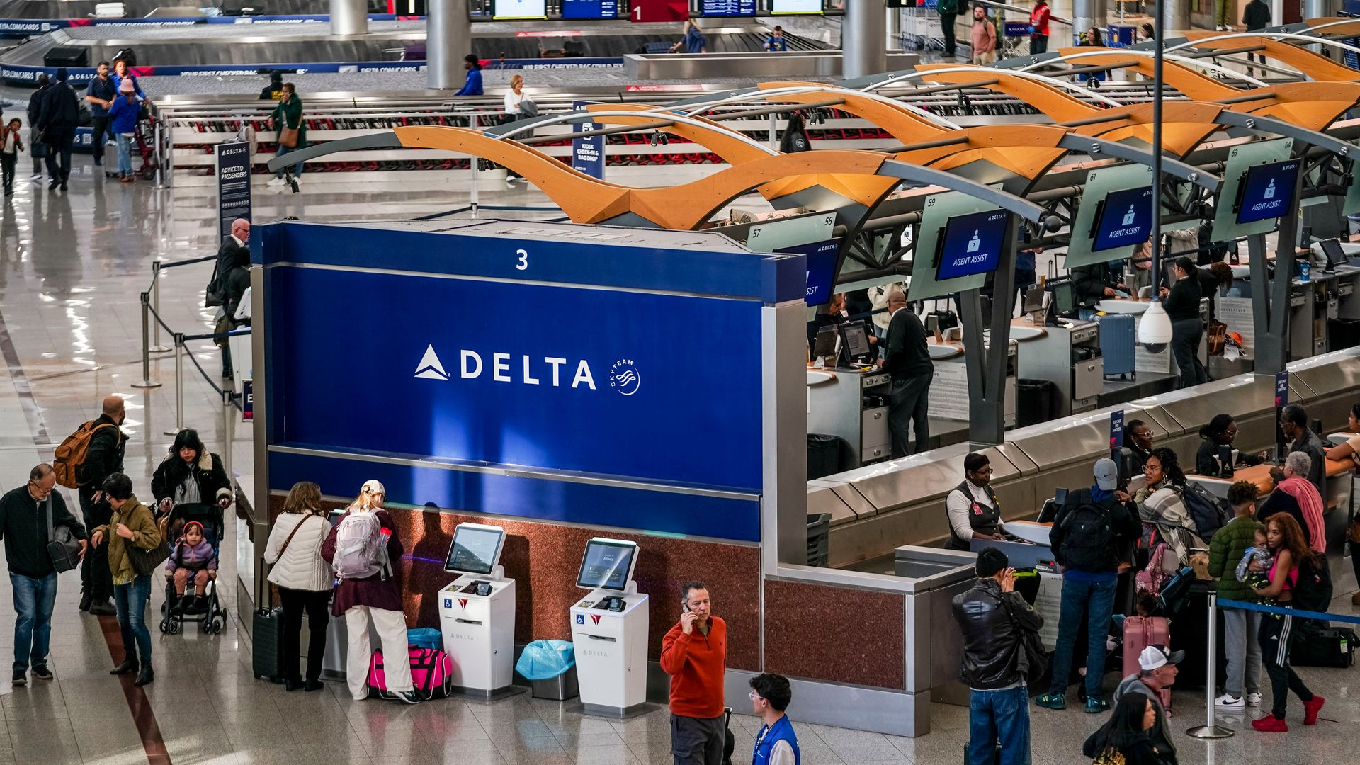 An overhead shot of the Delta Airlines check-in area, with travelers waiting in line, at Hartsfield-Jackson Atlanta International Airport.