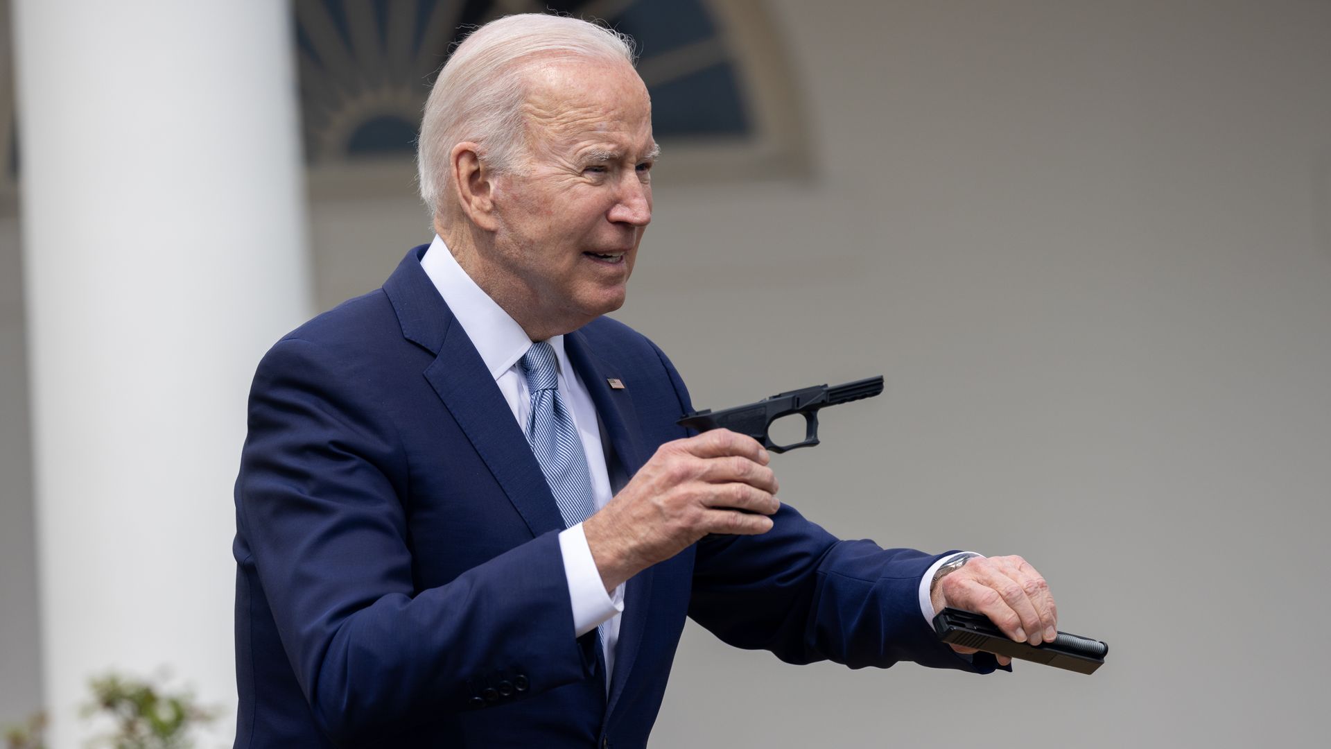 President Biden holds up pieces of a "ghost gun" kit on April 11.