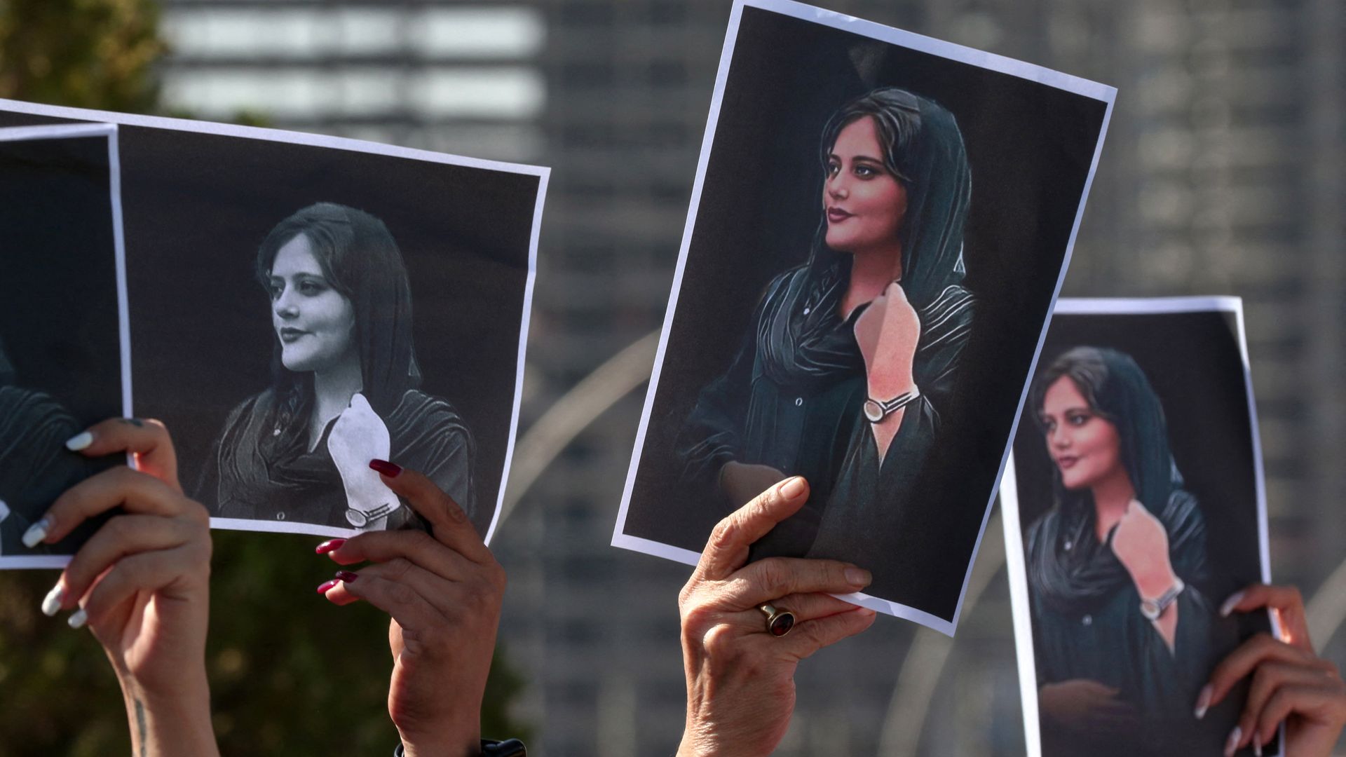 Women hold up signs depicting the image of 22-year-old Mahsa Amini, who died while in Iranian custody, during a demonstration  outside the UN offices in Arbil, Kurdistan region, on September 24.