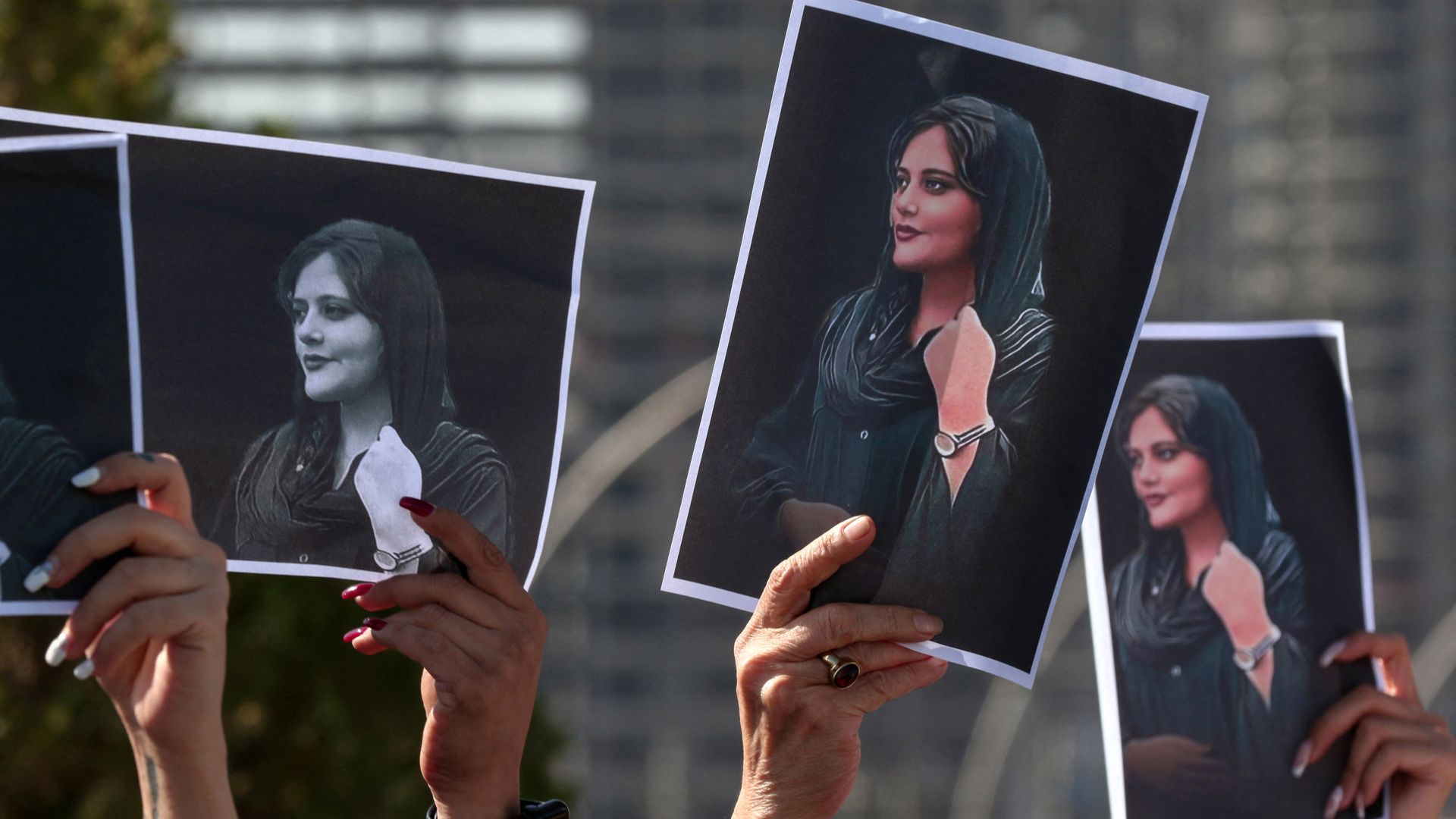 Women hold up signs depicting the image of 22-year-old Mahsa Amini, who died while in Iranian custody, during a demonstration outside the UN offices in Arbil, Kurdistan region, on September 24.