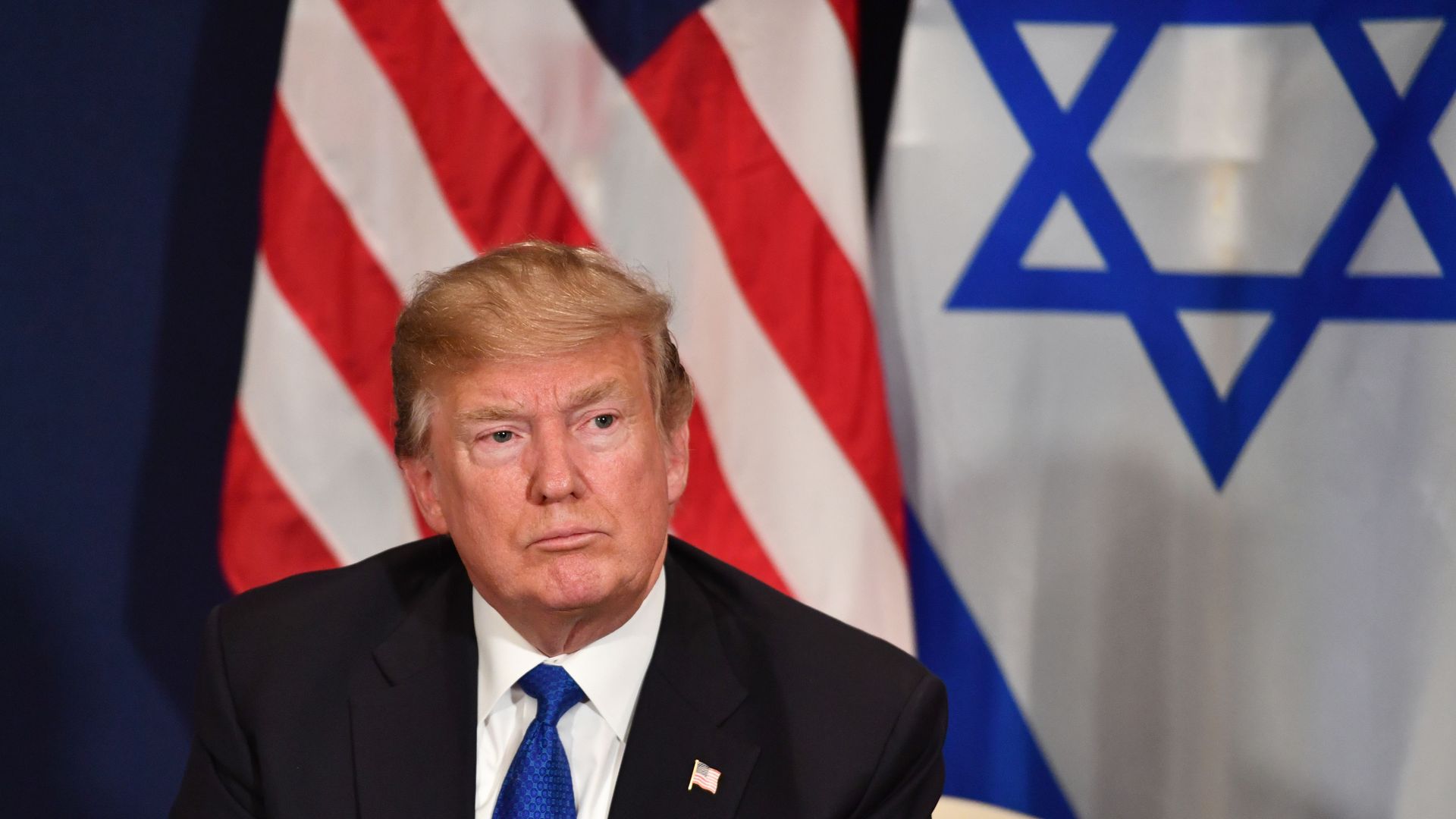 Trump with USA and Israel flags behind him