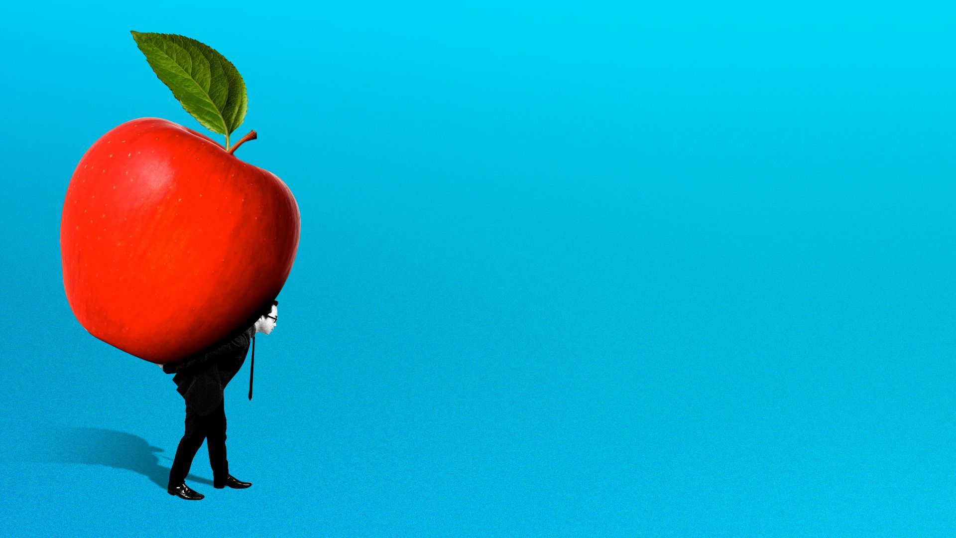 A person holds up a large apple and attempts to walk with it. 