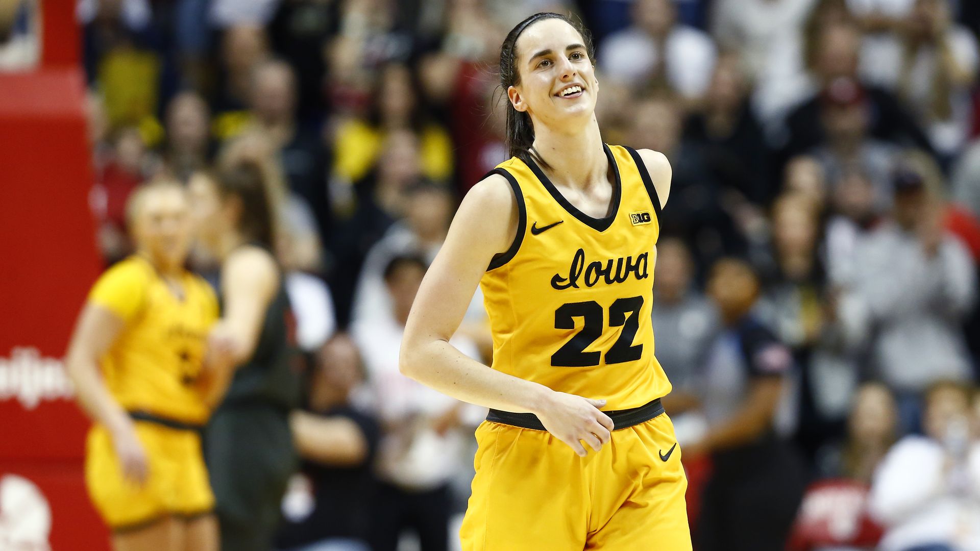 Caitlin Clark jogs on the court wearing an Iowa uniform.