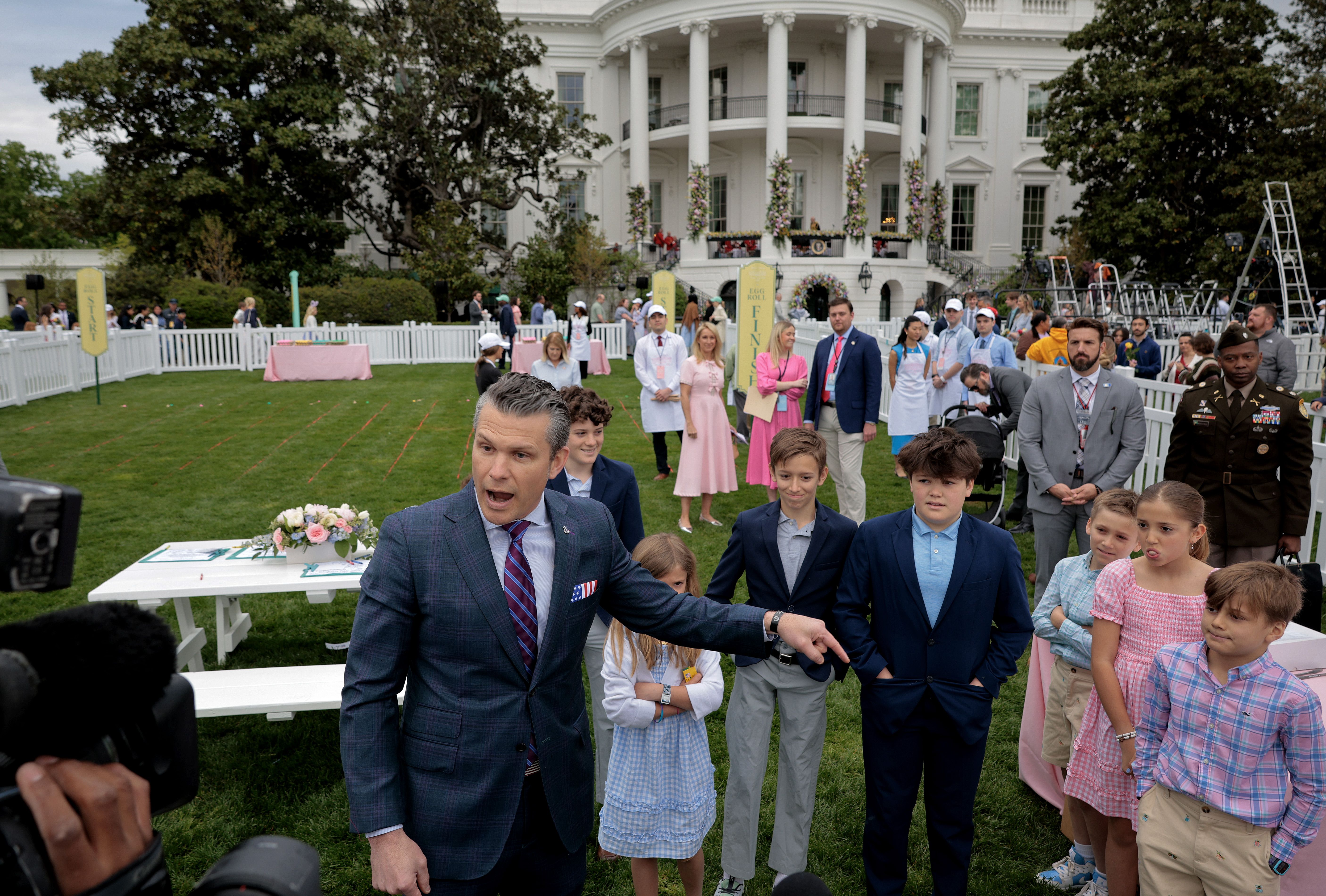 Pete Hegseth points as he speaks to reporters in front of the White House and egg roll attendees.
