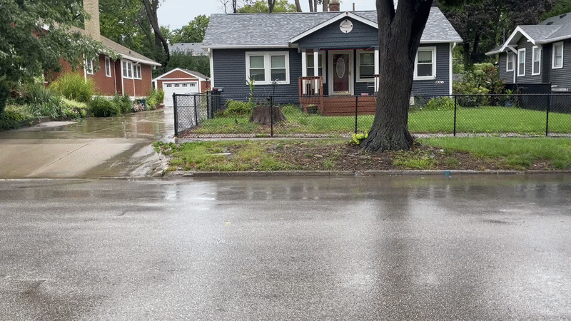 A Des Moines street cleaner on a street during heavy rain.
